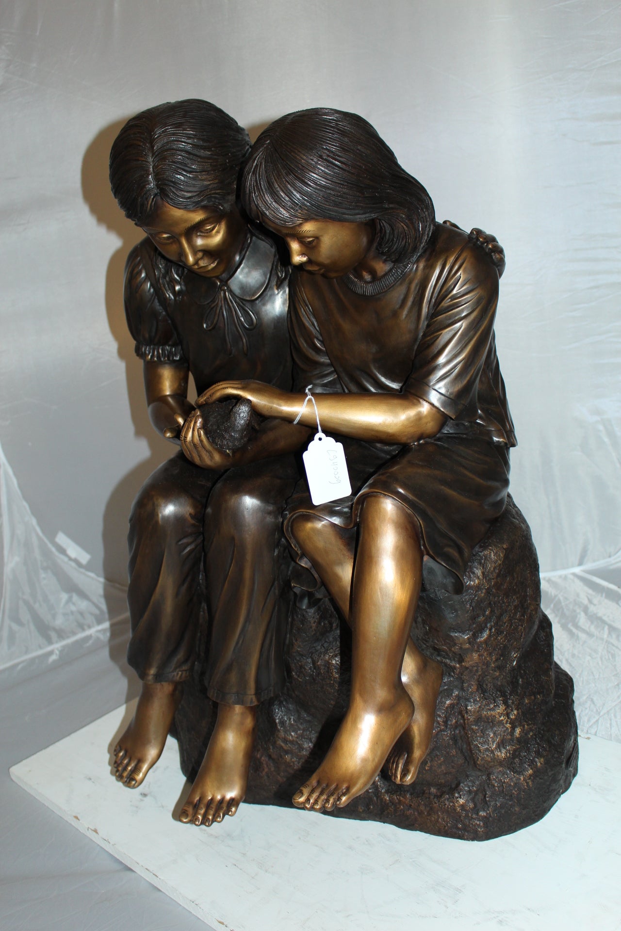 Two kids holding a bird Bronze Statue - Size: 18"L x 26"W x 34"H.