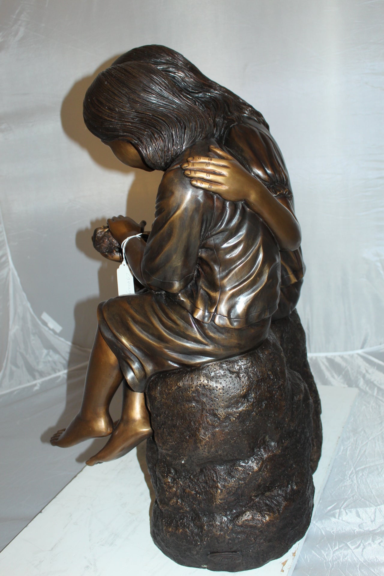 Two kids holding a bird Bronze Statue - Size: 18"L x 26"W x 34"H.