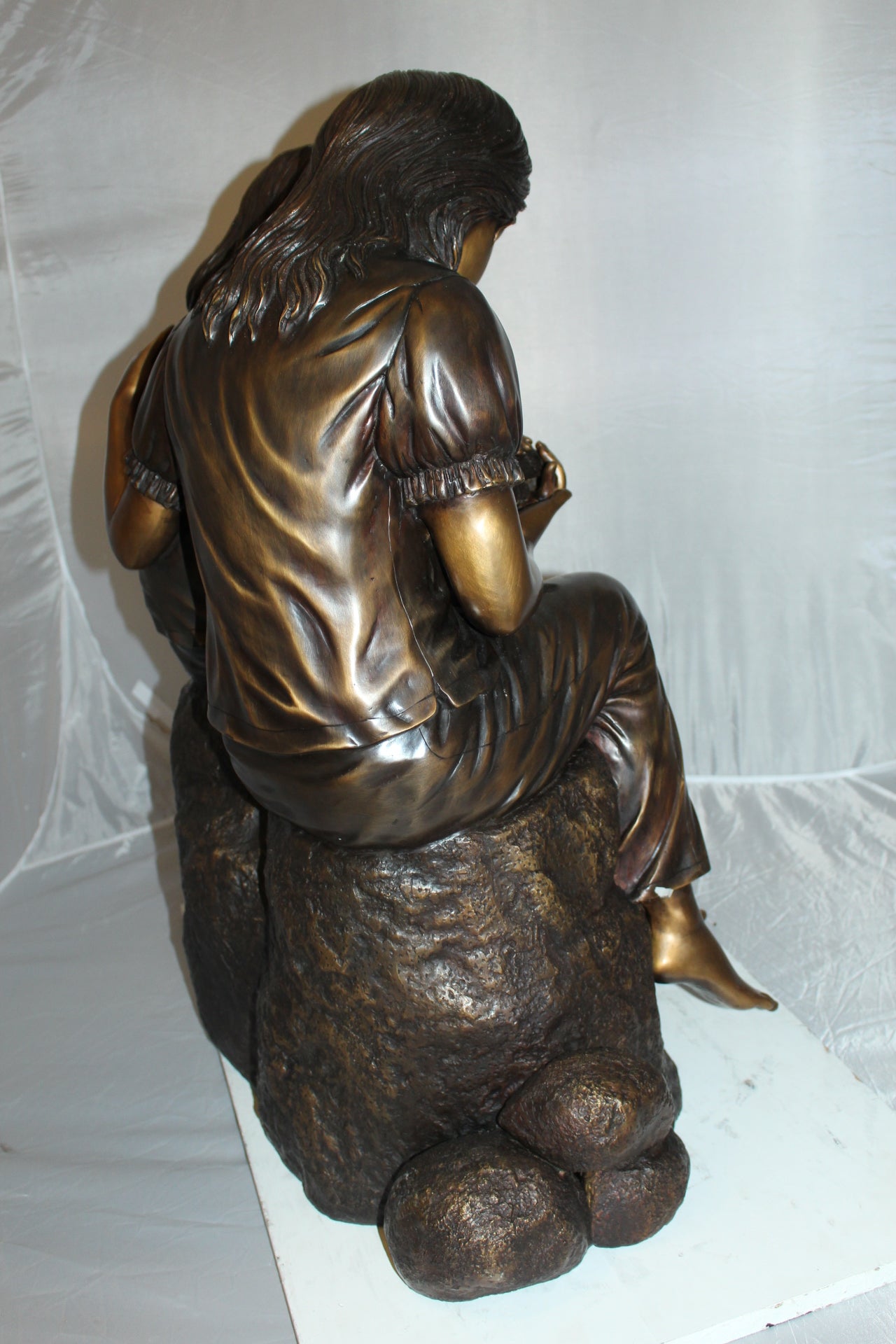 Two kids holding a bird Bronze Statue - Size: 18"L x 26"W x 34"H.