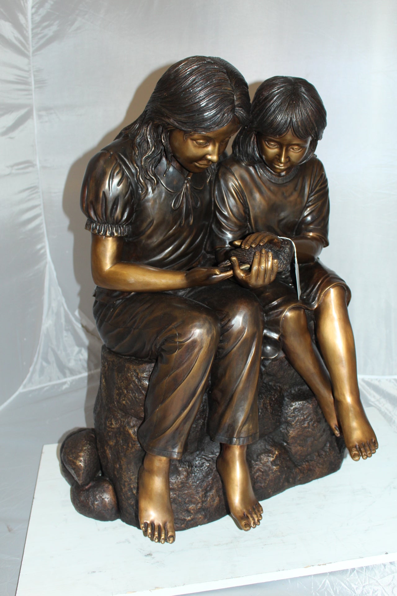 Two kids holding a bird Bronze Statue - Size: 18"L x 26"W x 34"H.