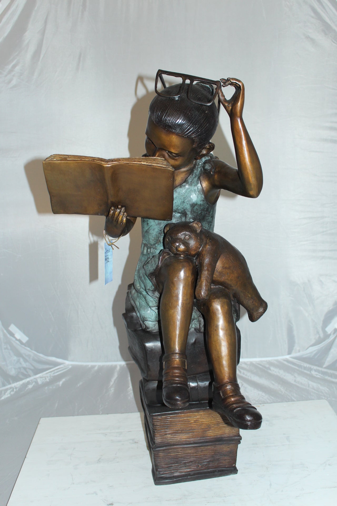 Girl sitting on a stack of books reading a book Bronze Statue - 17"x 18"x 36"H