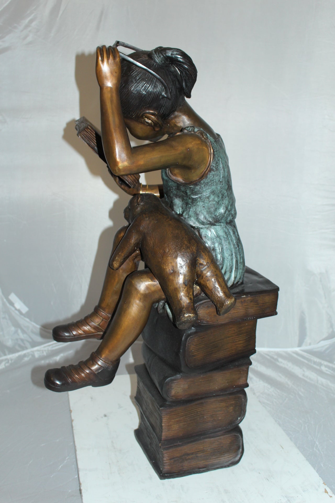 Girl sitting on a stack of books reading a book Bronze Statue - 17"x 18"x 36"H