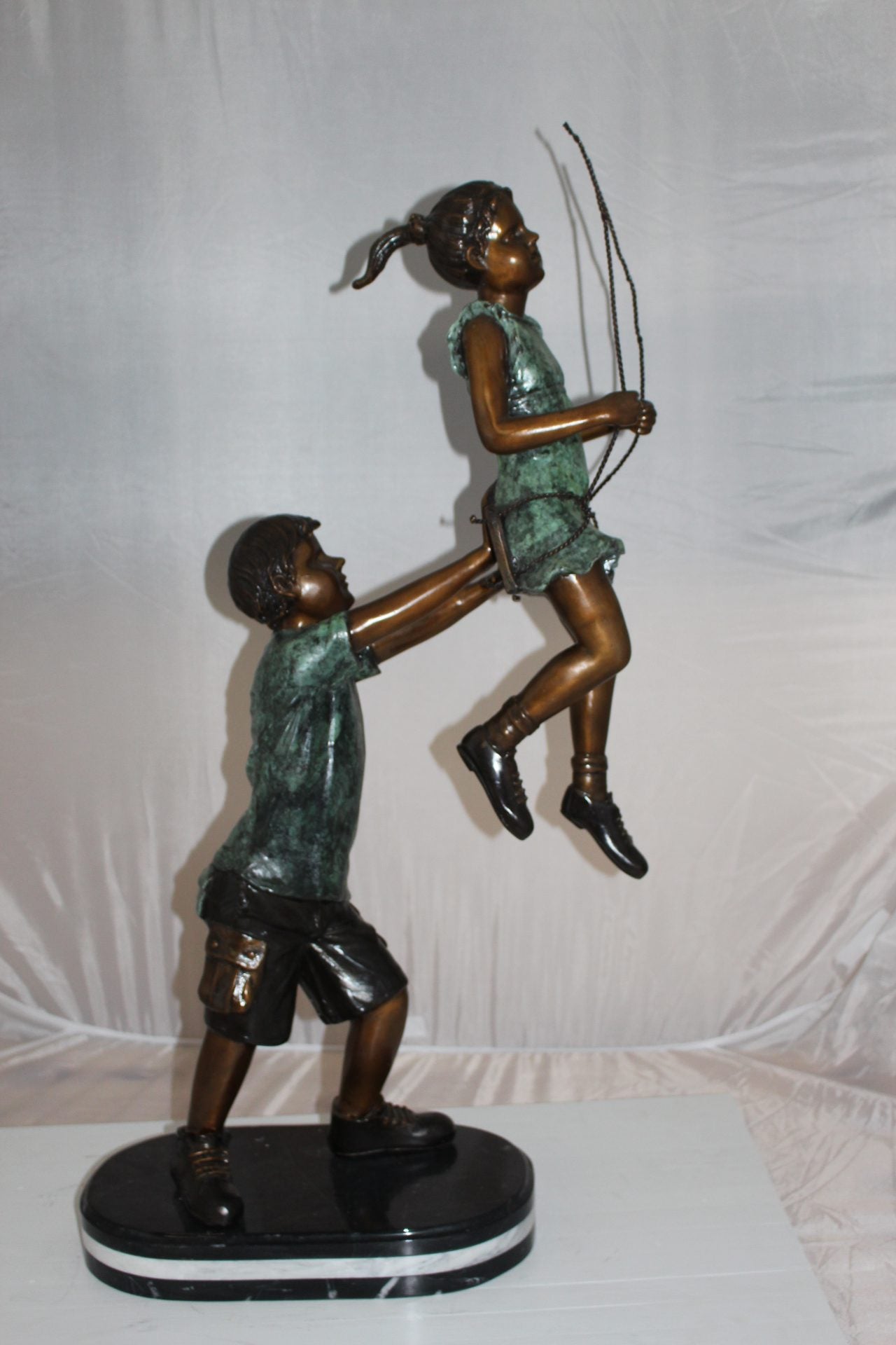 Children-on-swing-Bronze-Statue - Size: 20"L x 9"W x 39"H.