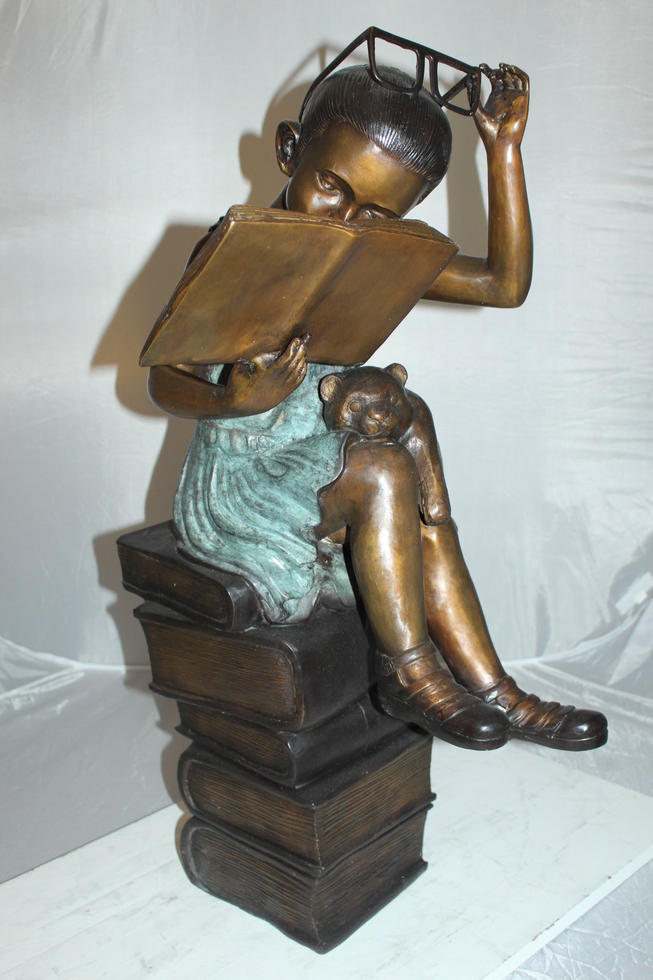 Girl sitting on a stack of books reading a book Bronze Statue - 17"x 18"x 36"H