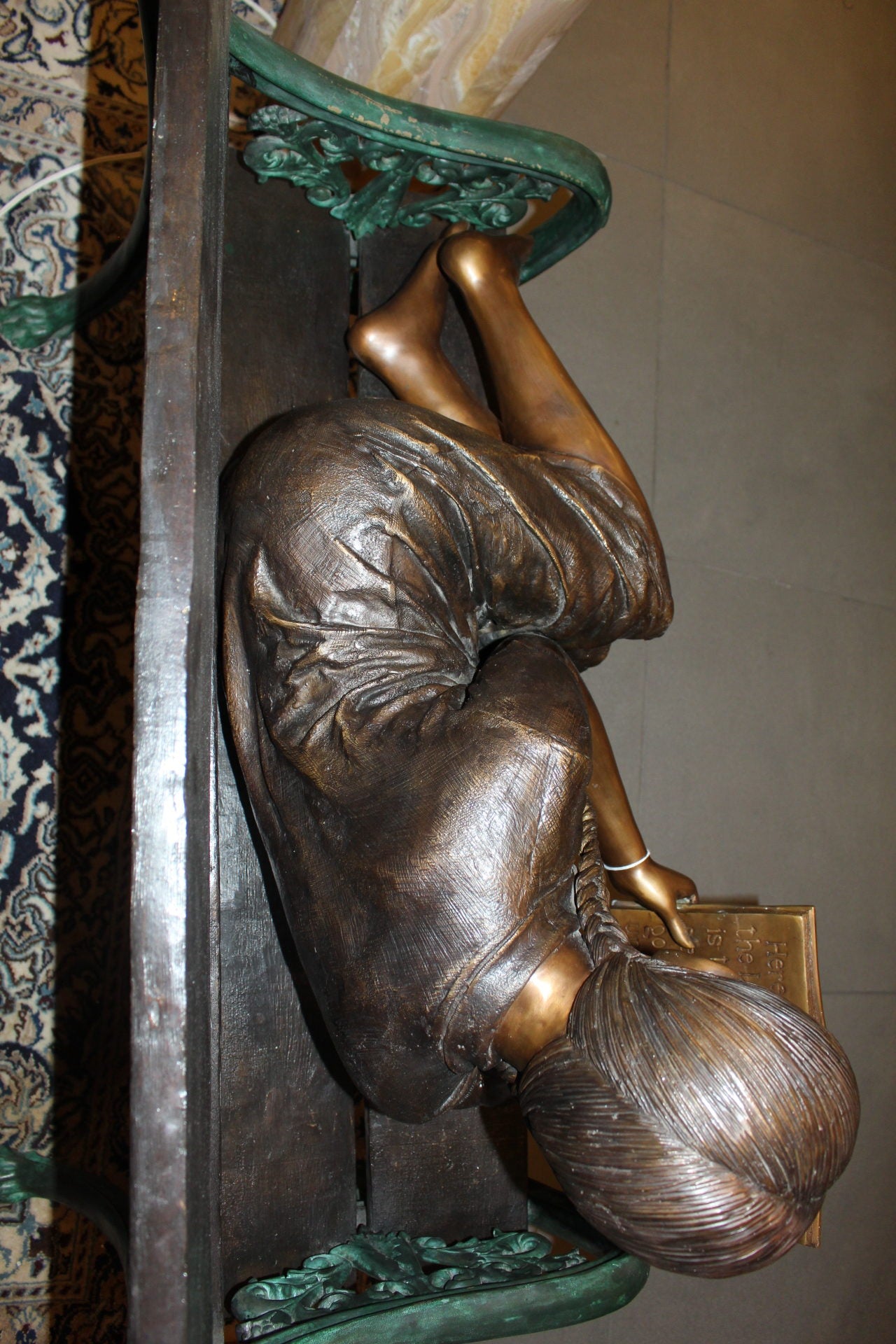 Girl laying on a bench reading a book Bronze Statue -  Size: 27"L x 39"W x 32"H