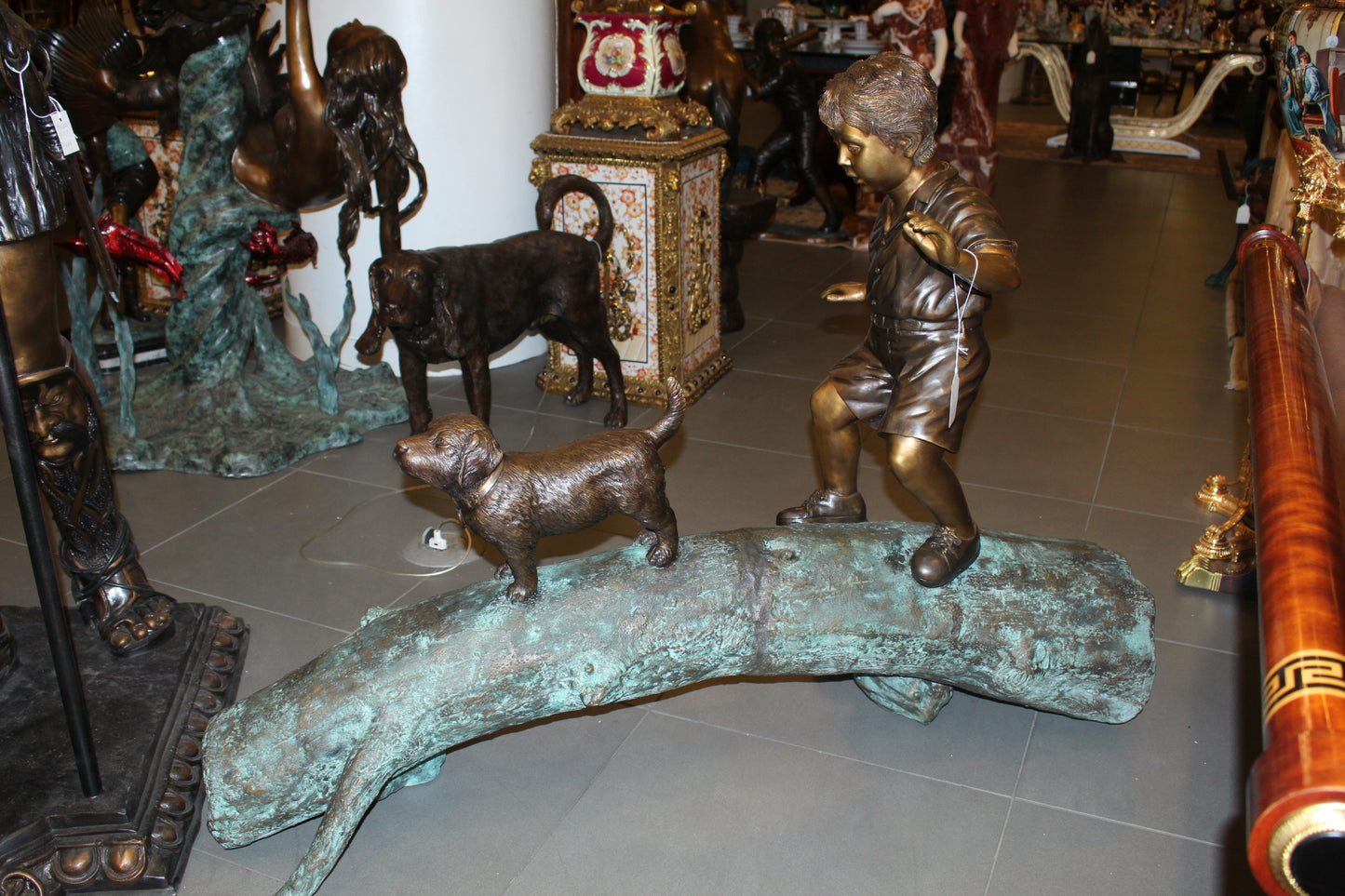 Kid with dog walking on a log Bronze Statue - Size: 57"L x 18"W x 41"H.