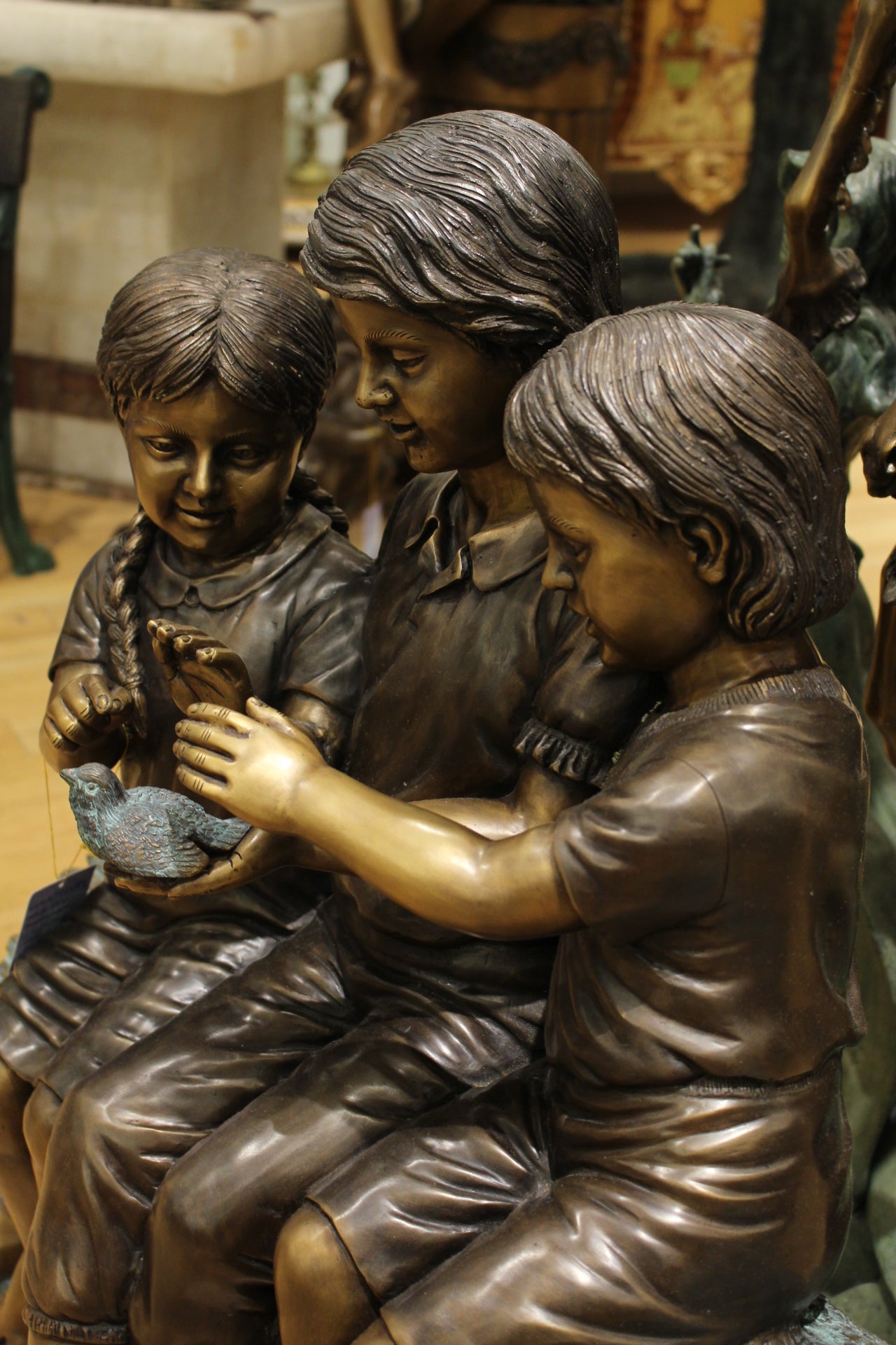 Three Children On Log Holding Bird Bronze Statue - Size: 55"L x 18"W x 38"H.
