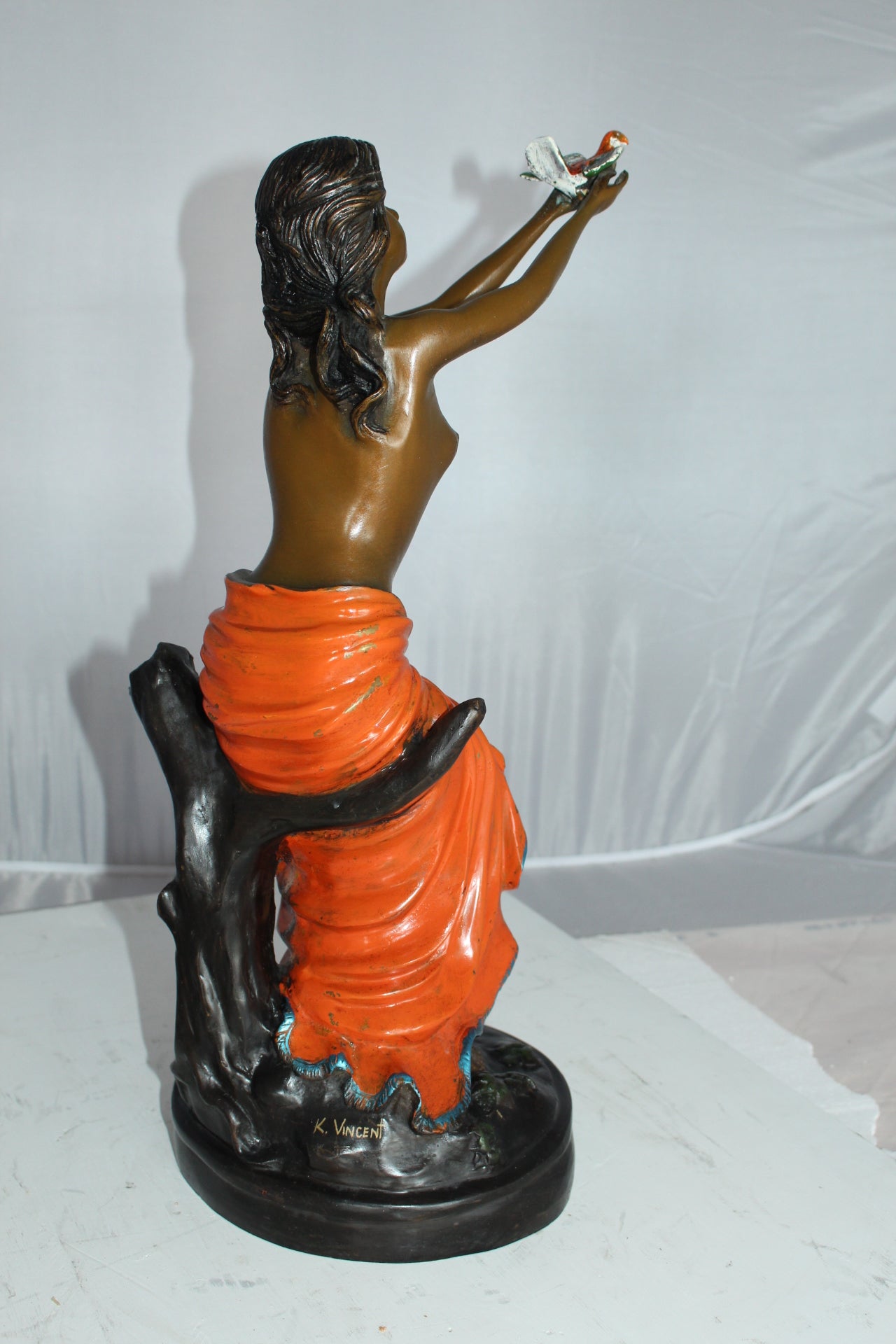 Lady Holds a Bird Up Bronze Statue - Size: 7"L x 7"W x 20"H.