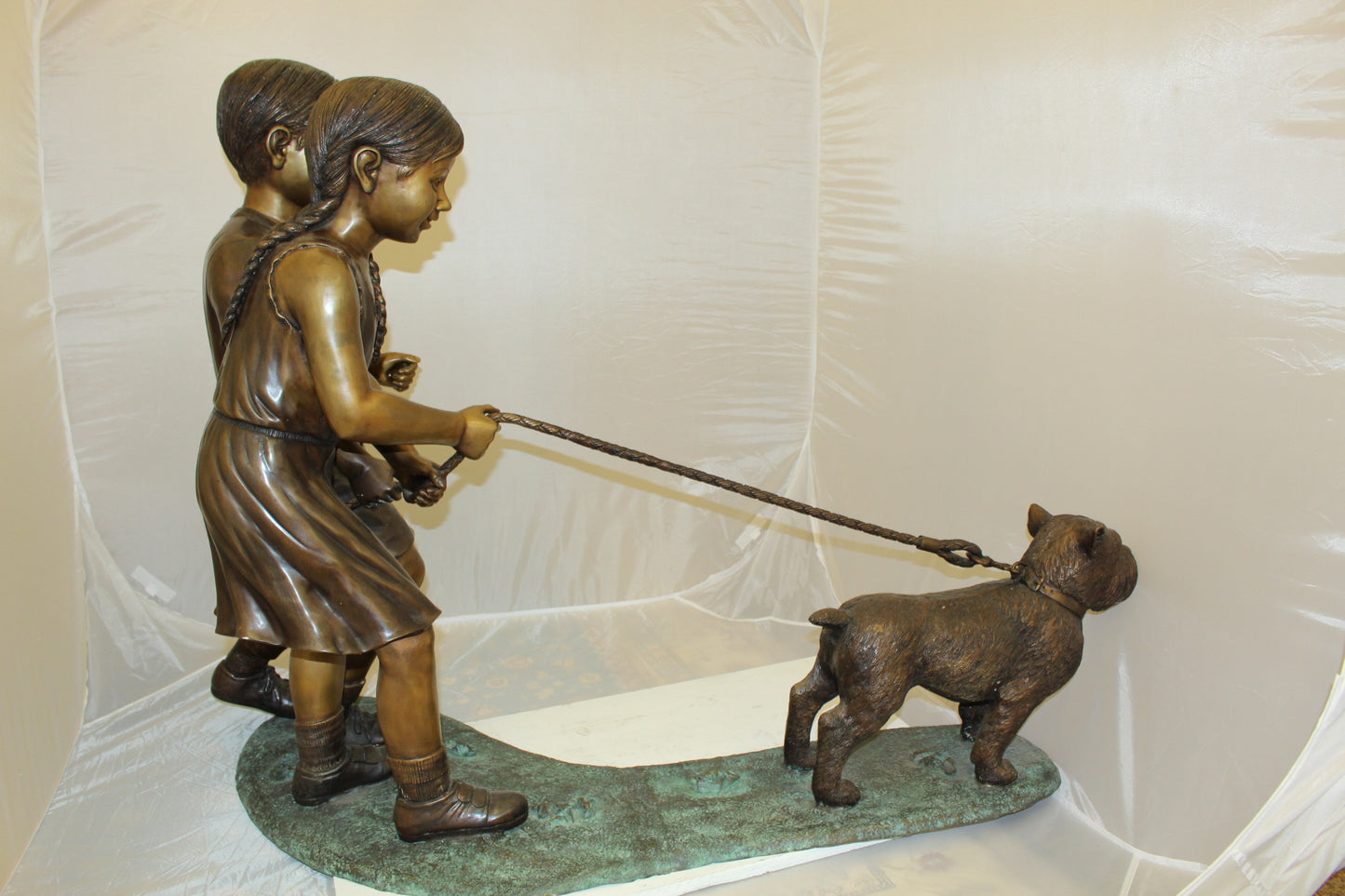 Two Kids Walking a dog Bronze Statue - Size: 55"L x 28"W x 37"H.