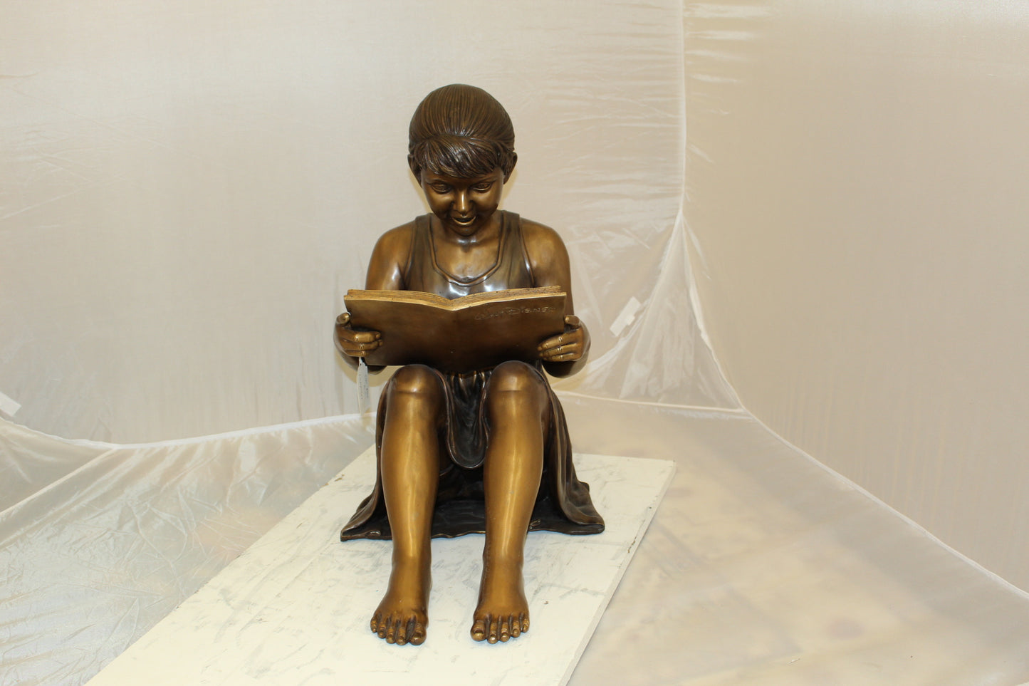 Girl Sitting and Reading a Book Bronze Statue - Size: 23"L x 15"W x 24"H.