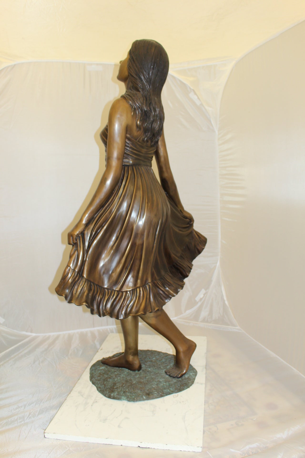 Lady holding her Skirt Bronze Statue - Size: 32"L x 17"W x 53"H.