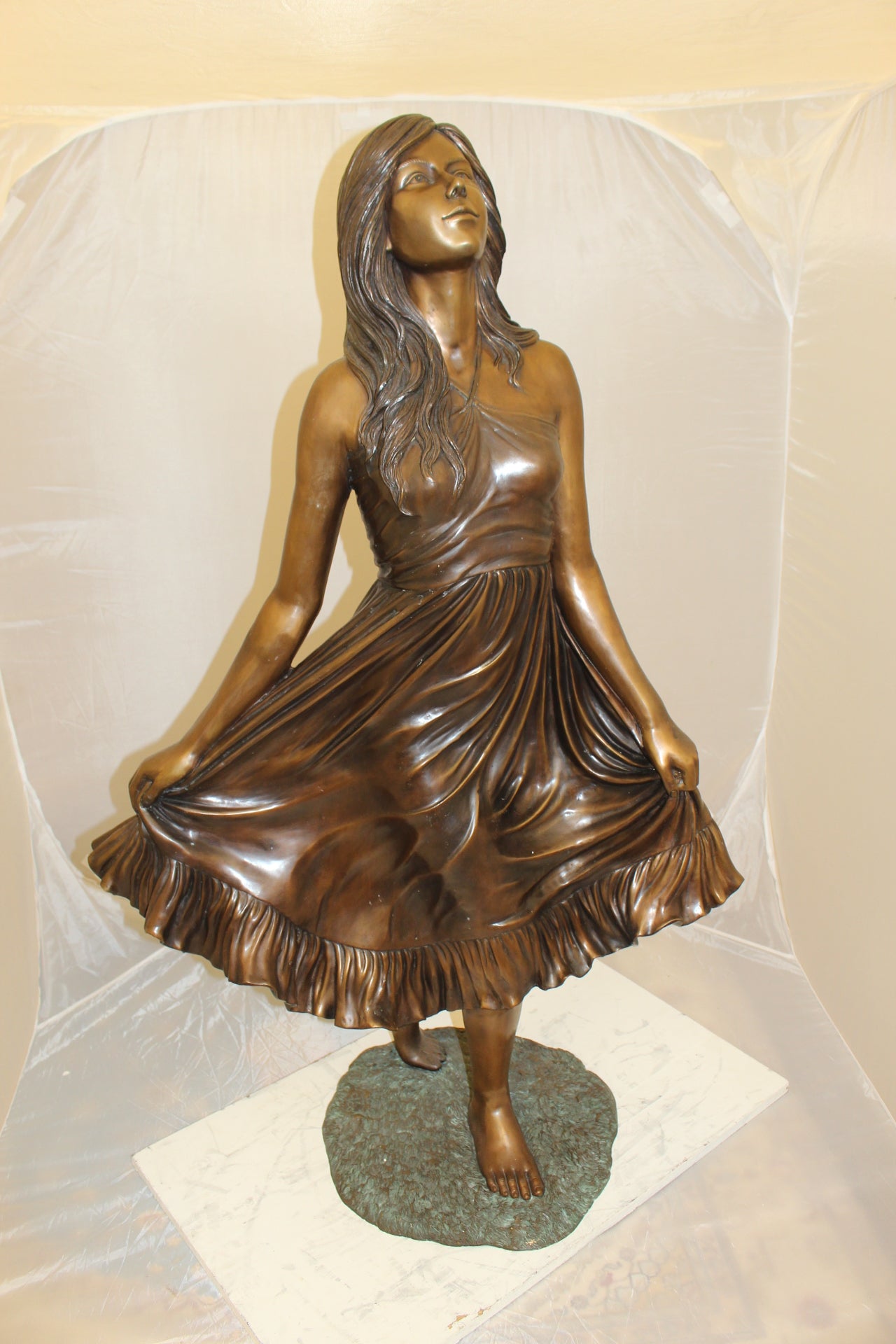 Lady holding her Skirt Bronze Statue - Size: 32"L x 17"W x 53"H.