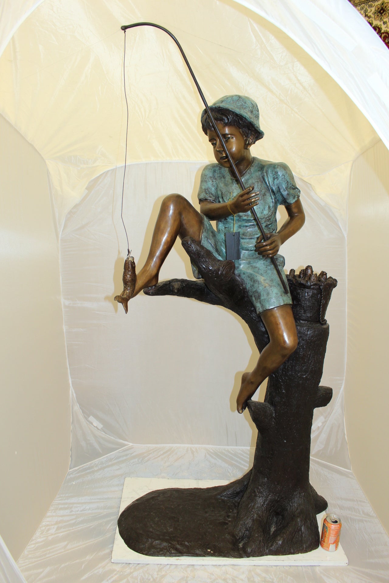 Boy Sitting on a Tree and Fishing Bronze Statue - Size: 36"L x 21"W x 37"H.