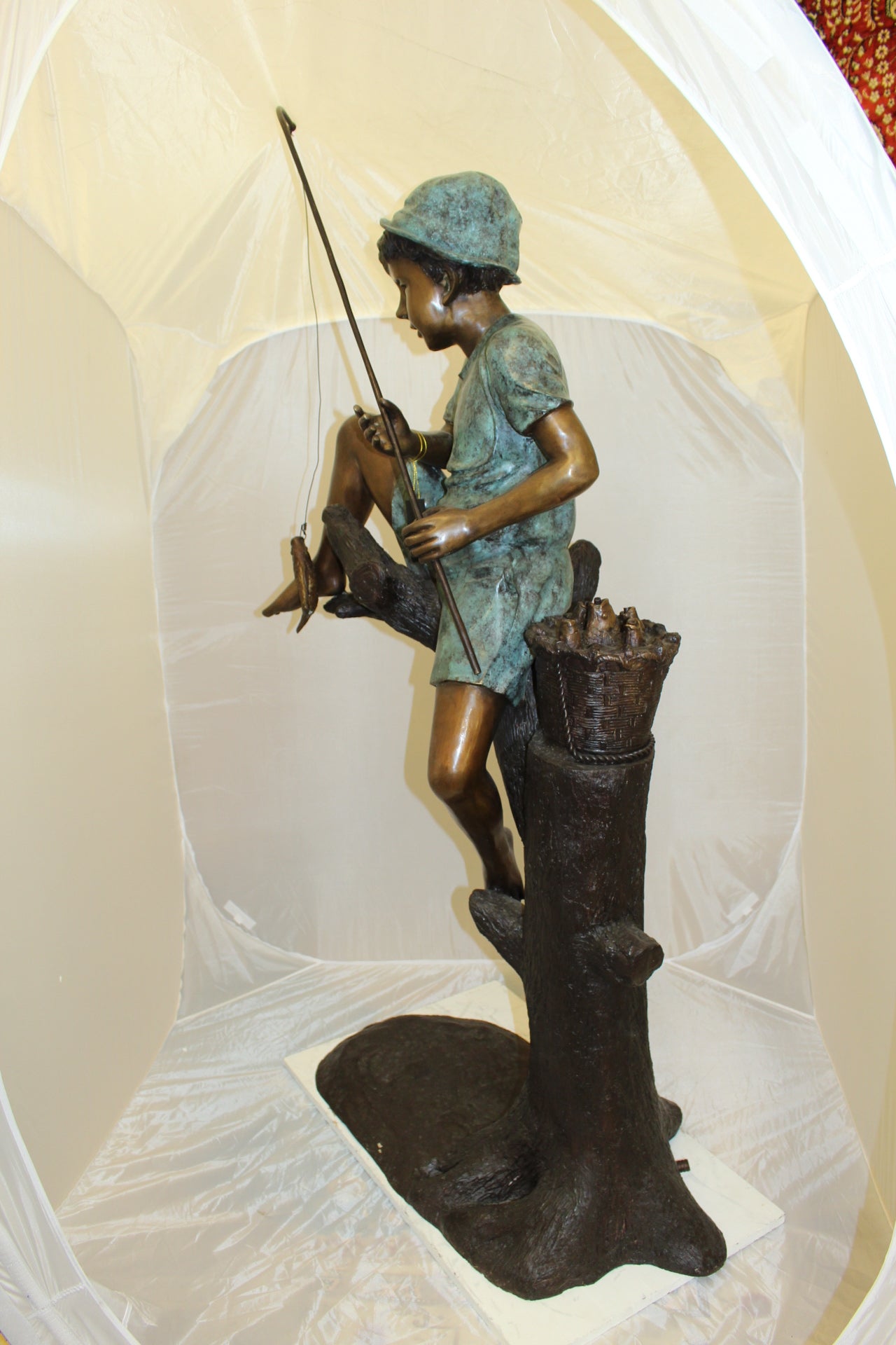 Boy Sitting on a Tree and Fishing Bronze Statue - Size: 36"L x 21"W x 37"H.