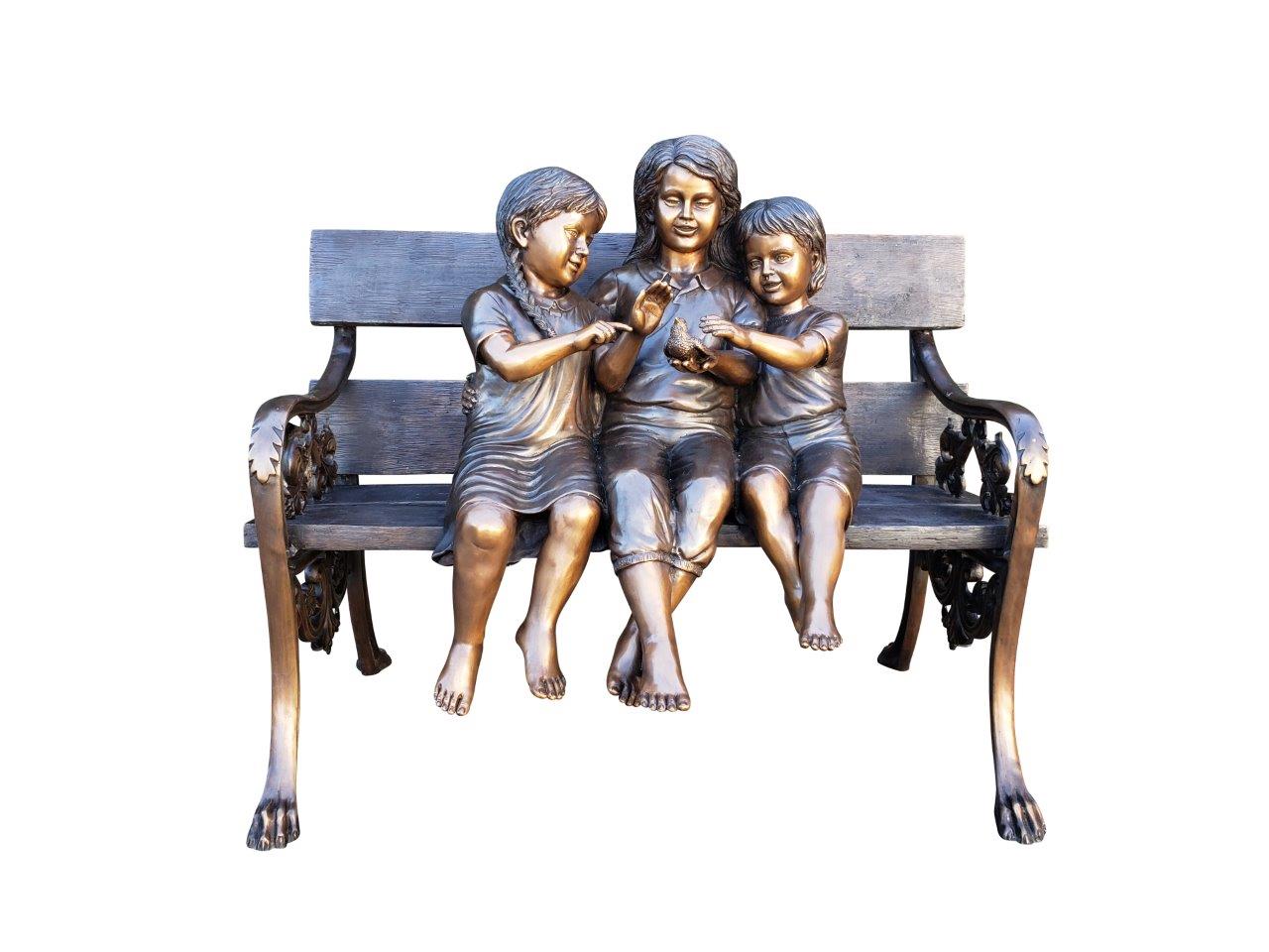 Three kids on a Bench Holding a Bird Bronze Statue - Size: 40"L x 30"W x 33"H.