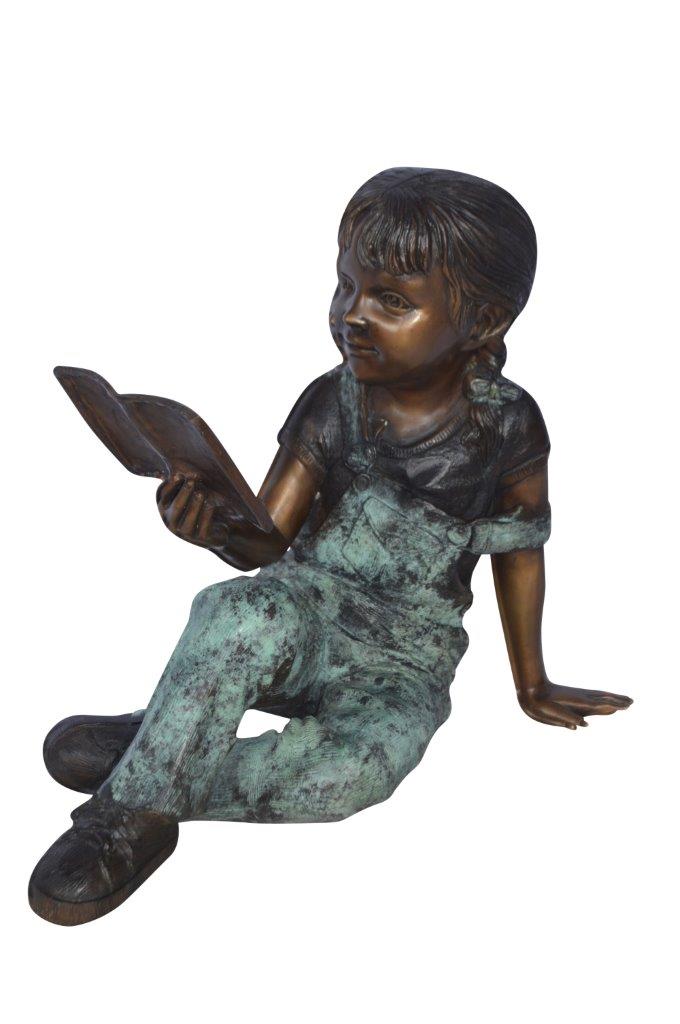 Young girl laying and reading book bronze statue - Size: 18"L x 9"W x 16"H.