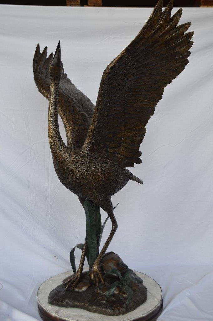 Crane standing on a stone bronze statue - Size: 28"L x 32"W x 49"H.