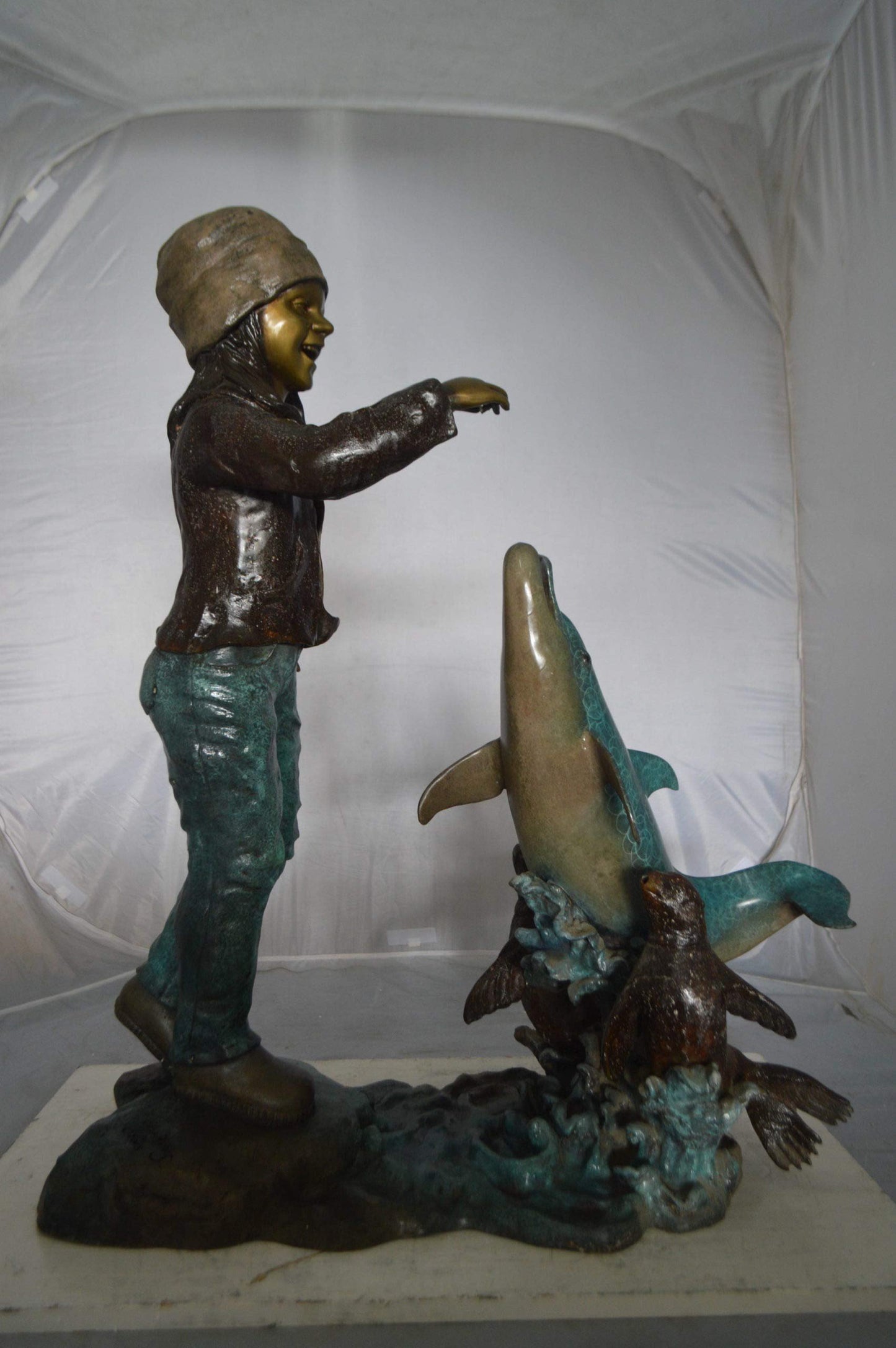 Girl feeding a dolphin and seals bronze fountain - Size: 28"L x 17"W x 37"H.