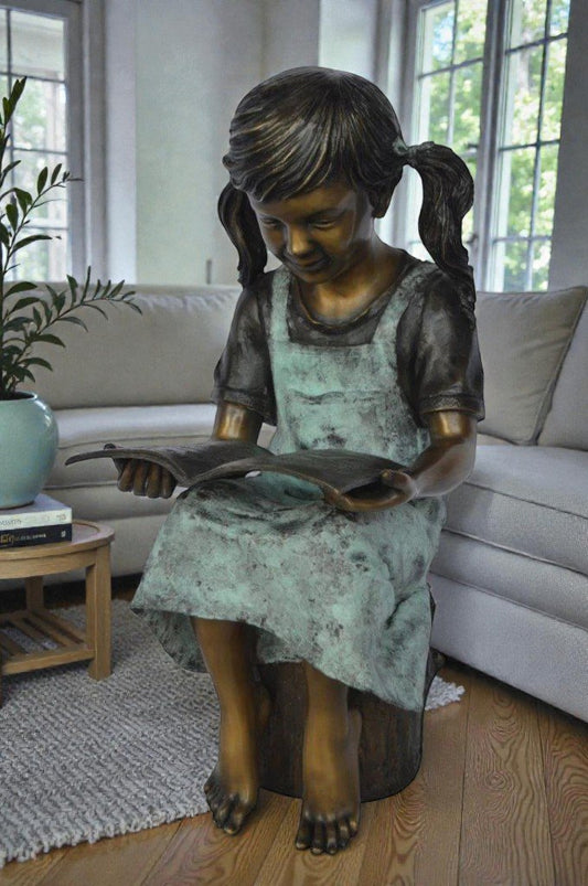 Young girl sitting and reading book bronze statue - Size: 16"L x 12"W x 27"H.