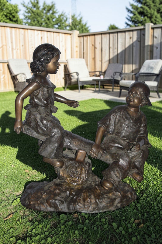 A Boy and a Girl Playing Seesaw Bronze Statue - Size: 17"L x 33"W x 36"H.