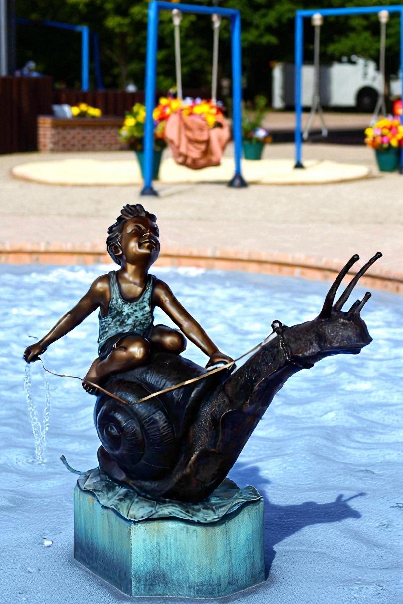 Happy boy riding a snail bronze statue fountain -  Size: 42"L x 14"W x 34"H.
