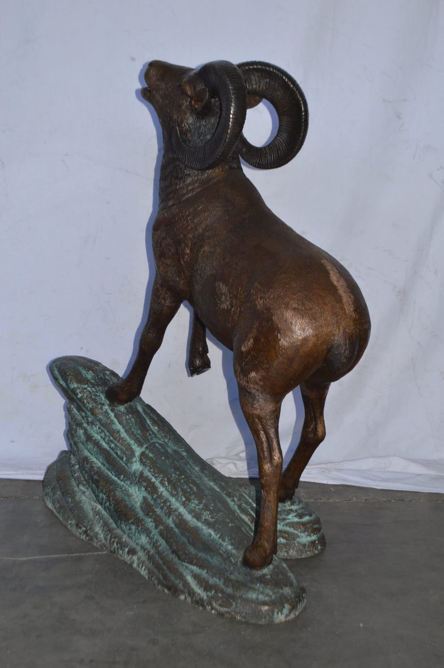 Life Size Ram standing on a rock Bronze Statue - Size: 38"L x 19"W x 45"H.