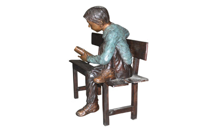 boy Sitting on a Bench reading book bronze Statue -  Size: 43"L x 20"W x 36"H.
