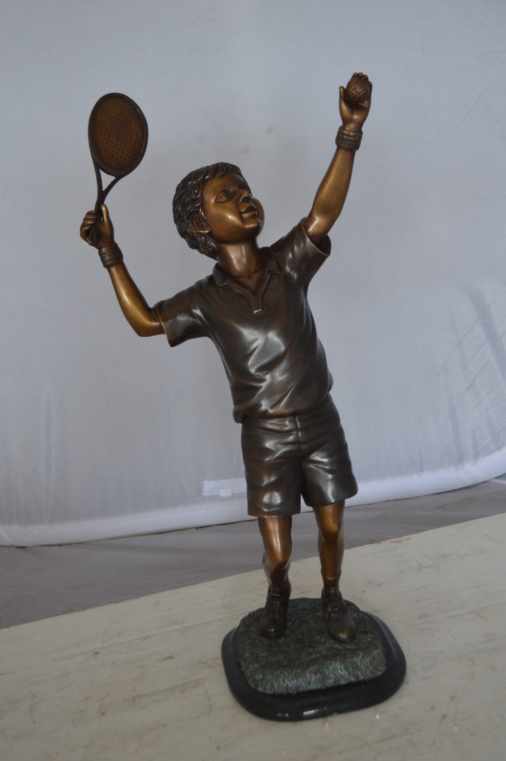 Boy Playing Tennis Bronze Statue -  Size: 12"L x 8"W x 25"H. 