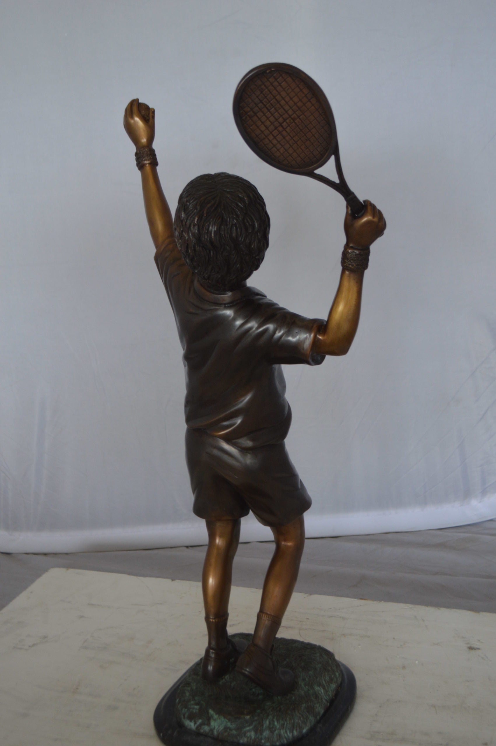 Boy Playing Tennis Bronze Statue -  Size: 12"L x 8"W x 25"H. 