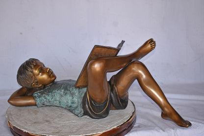 Kid on A Pillow Reading a Book Bronze Statue - Size: 32"L x 13"W x 12"H.