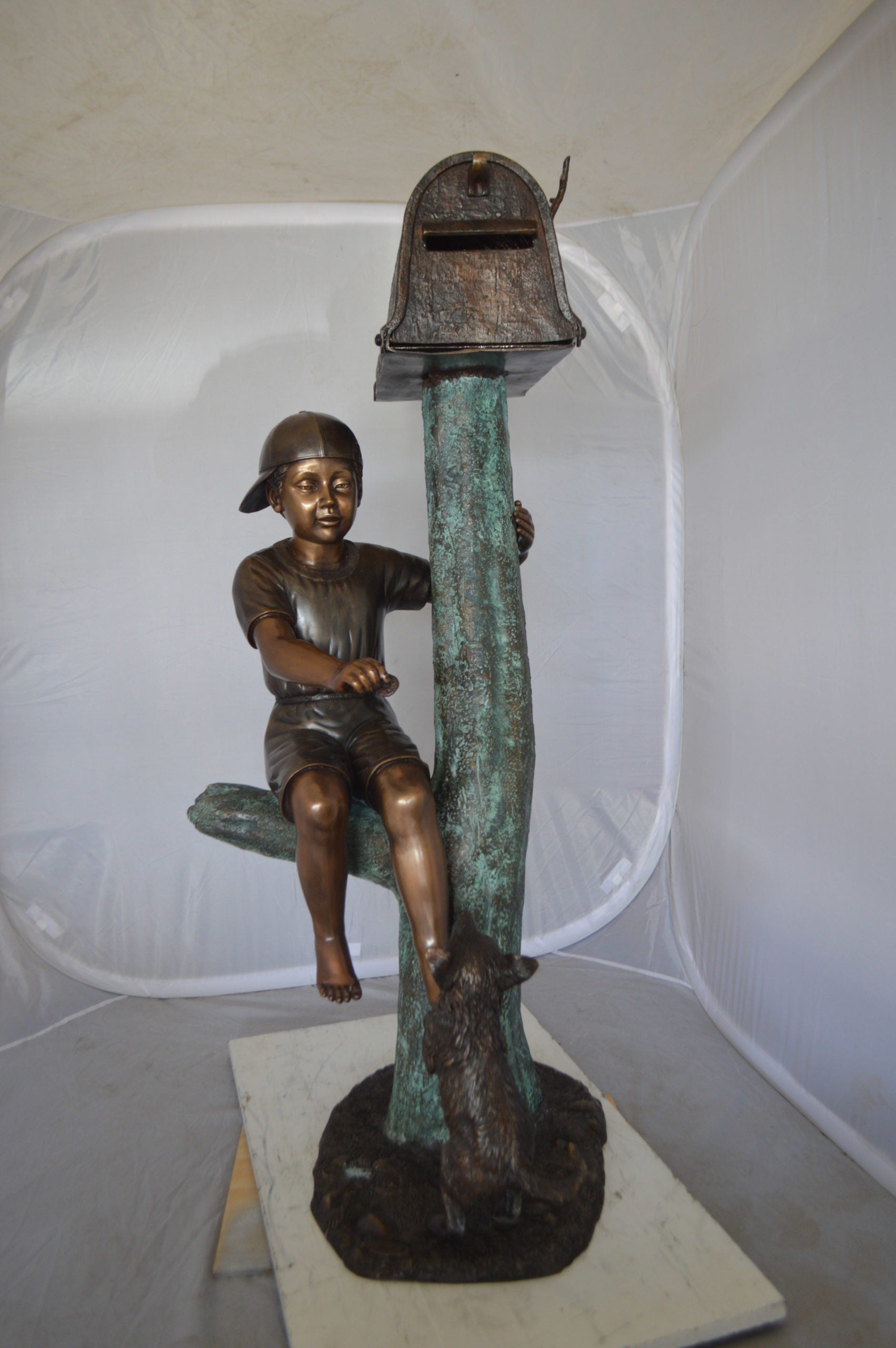 Boy Sitting on a Tree with Mailbox Bronze Statue -  Size: 22"L x 23"W x 49"H. 