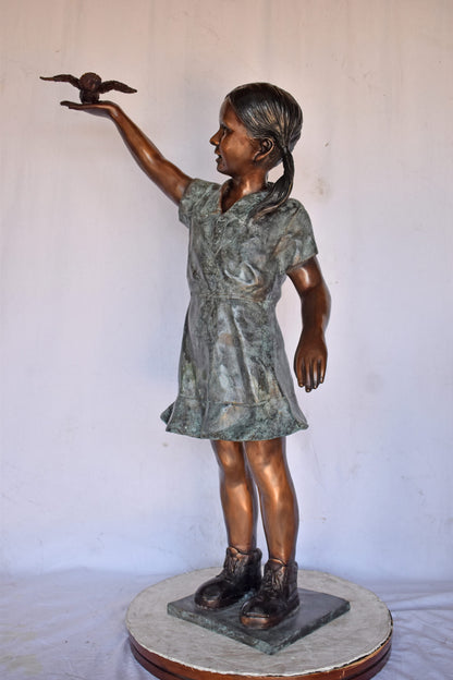 Young Girl Holding a Bird Outside at The Park - Size: 21"L x 11"W x 49"H.