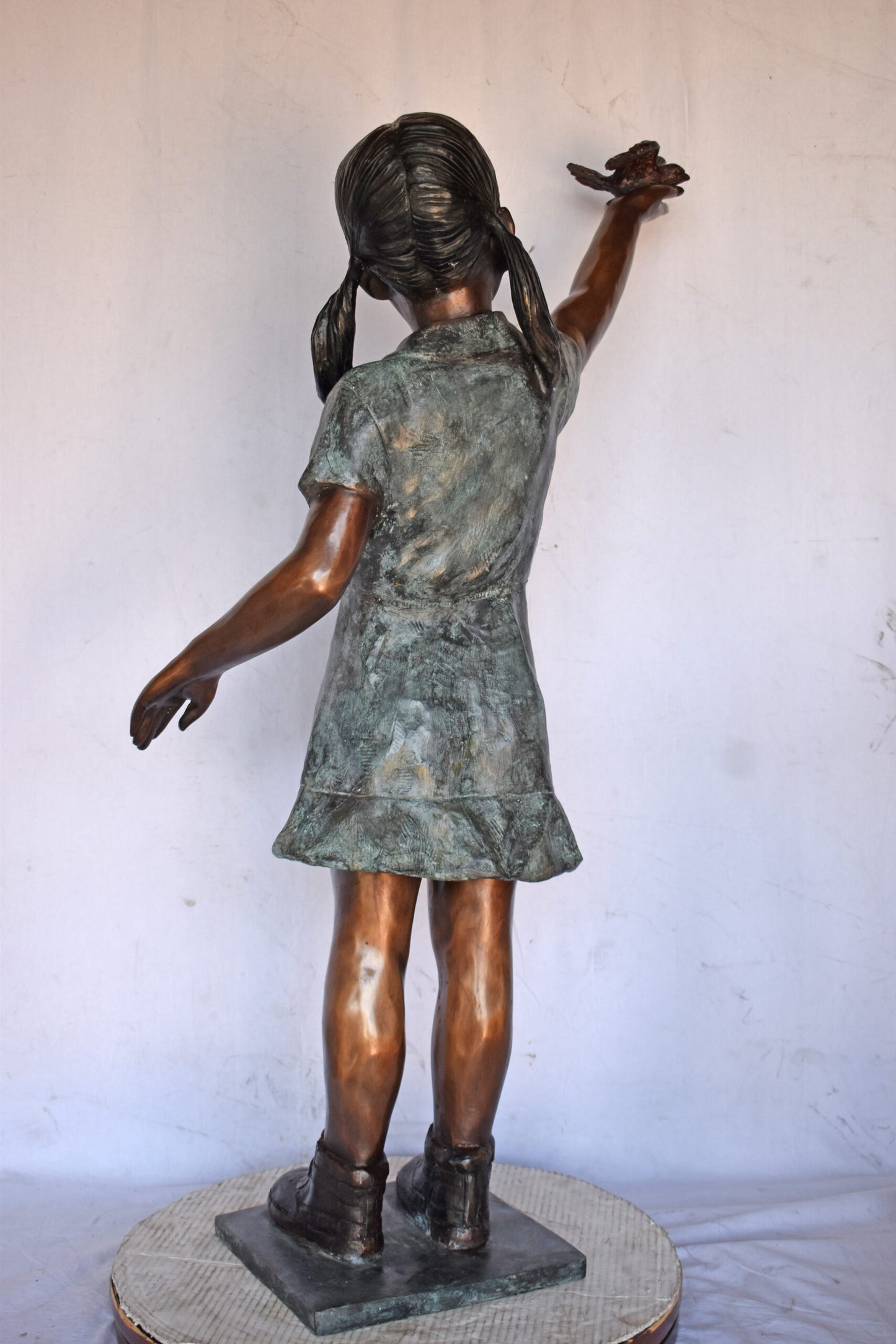 Young Girl Holding a Bird Outside at The Park - Size: 21"L x 11"W x 49"H.