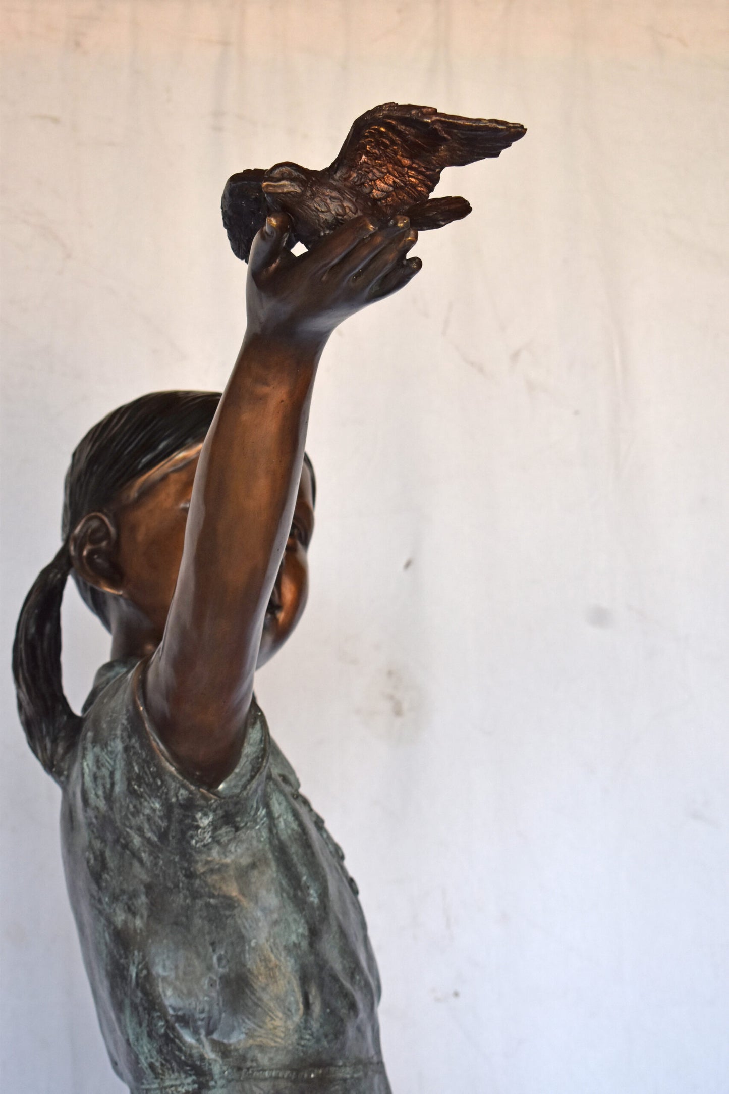 Young Girl Holding a Bird Outside at The Park - Size: 21"L x 11"W x 49"H.