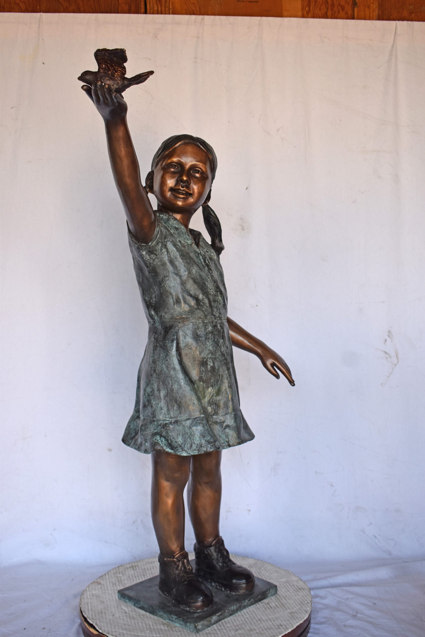 Young Girl Holding a Bird Outside at The Park - Size: 21"L x 11"W x 49"H.