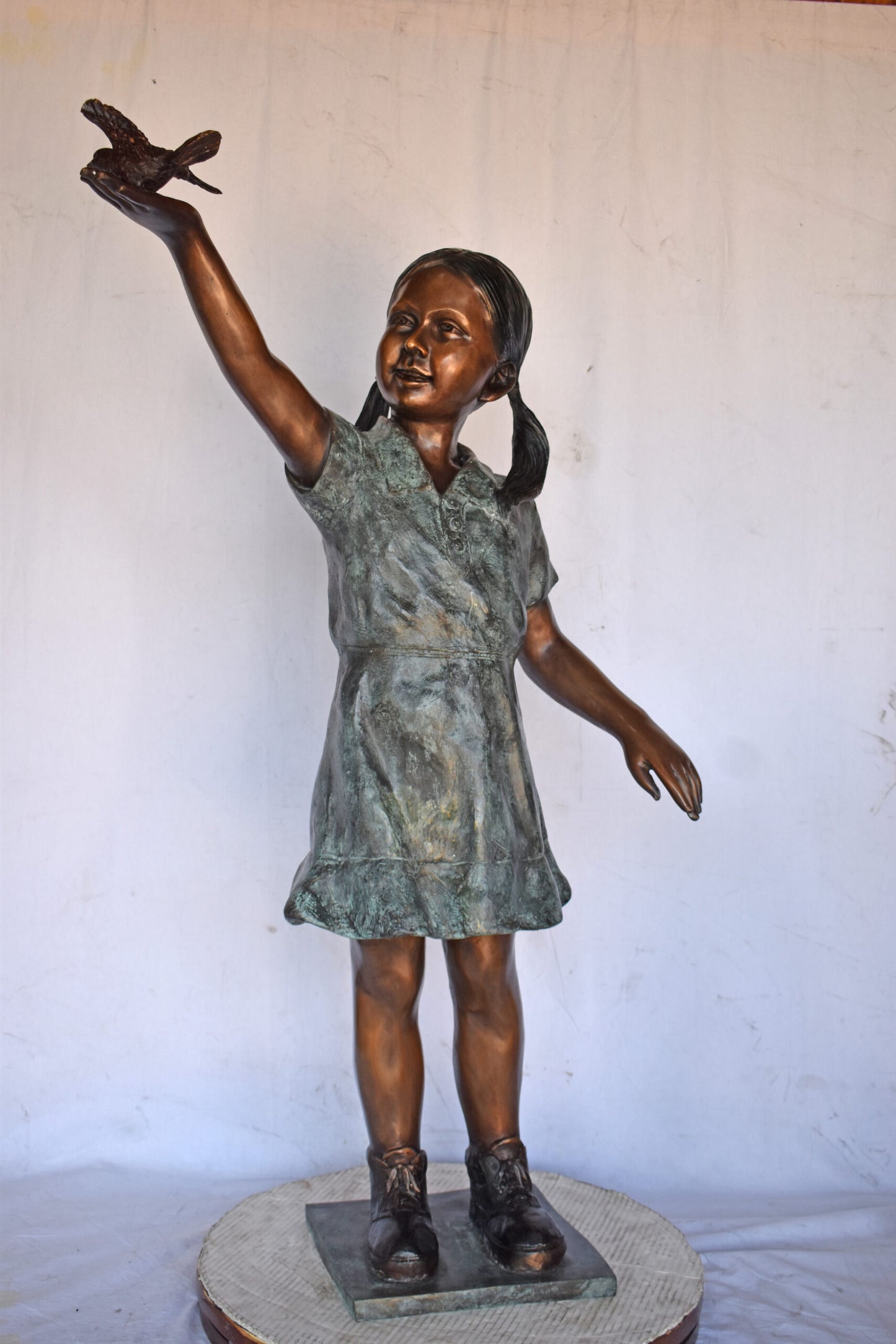 Young Girl Holding a Bird Outside at The Park - Size: 21"L x 11"W x 49"H.