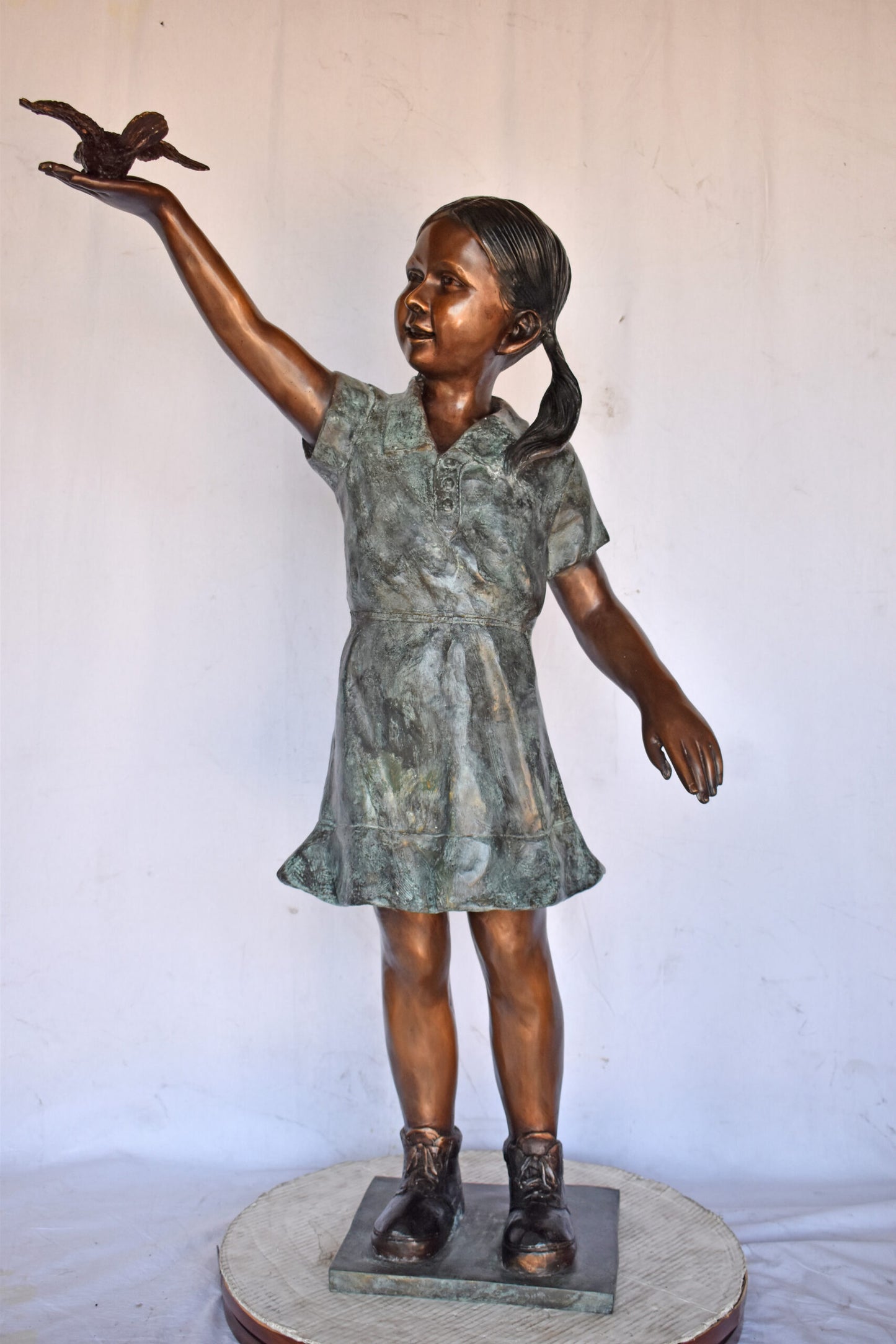 Young Girl Holding a Bird Outside at The Park - Size: 21"L x 11"W x 49"H.