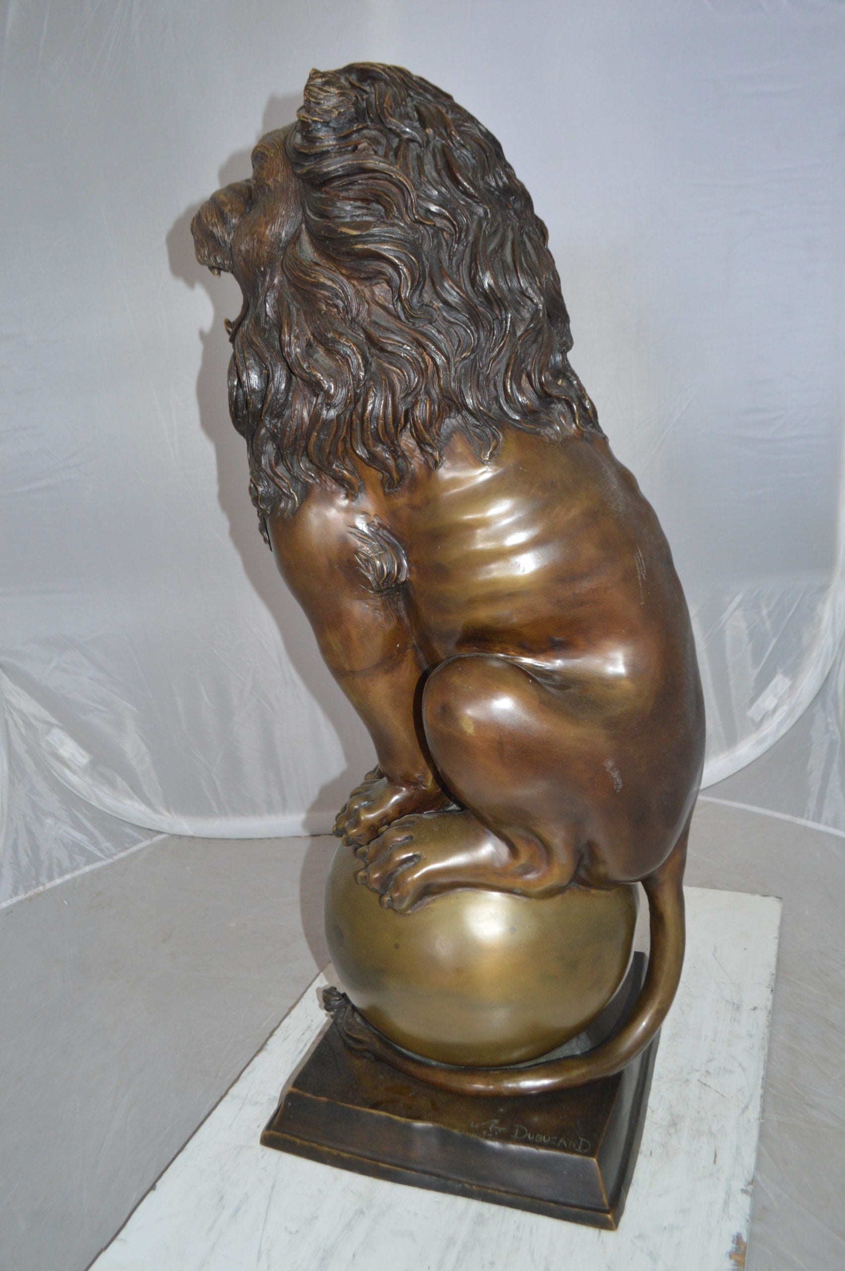 Pair of lions standing on balls, bronze statues -  Size: 14"L x 16"W x 38"H. 