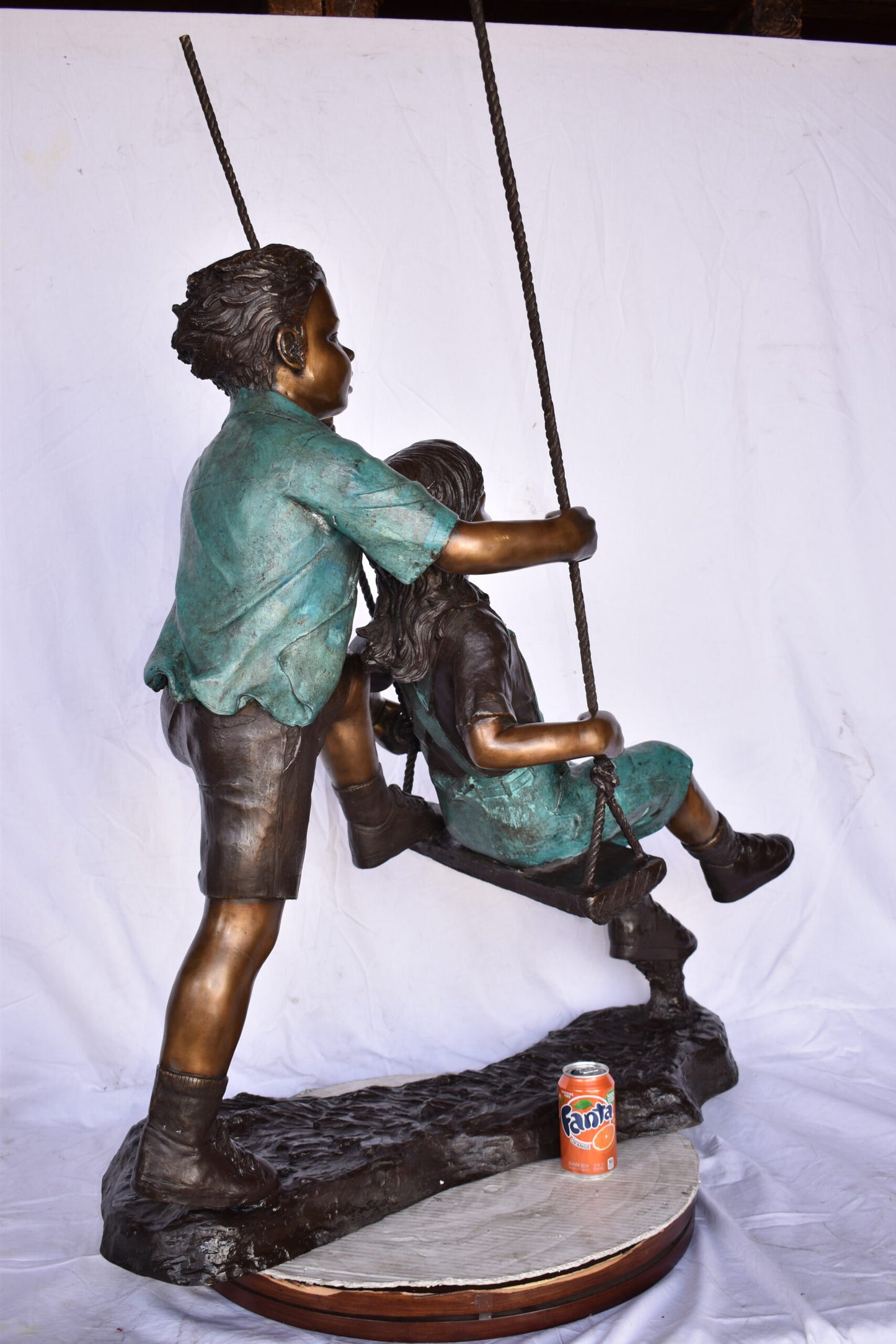 Boy and Girl Playing on a Swing bronze Statue - Size: 39"L x 17"W x 53"H.