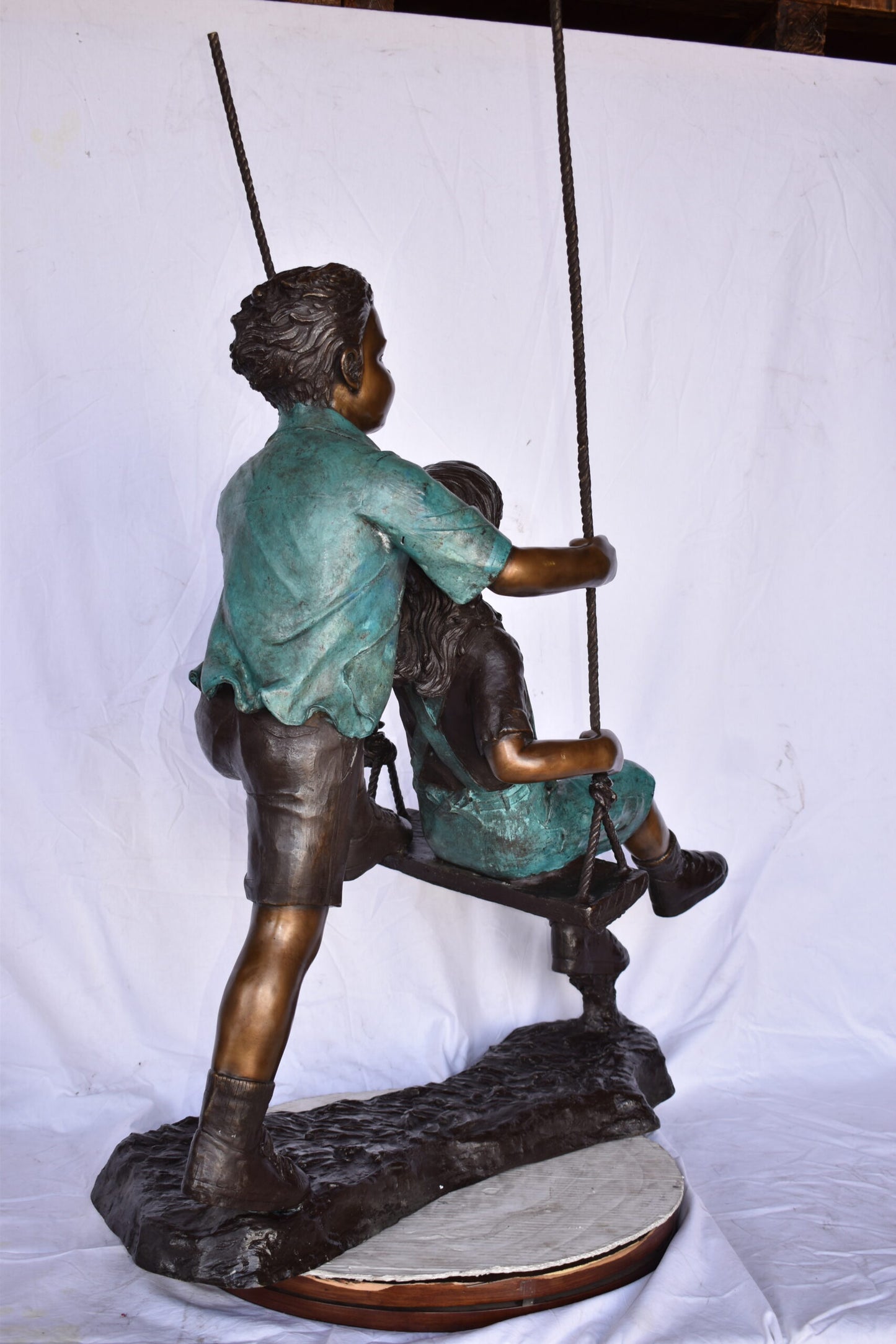 Boy and Girl Playing on a Swing bronze Statue - Size: 39"L x 17"W x 53"H.