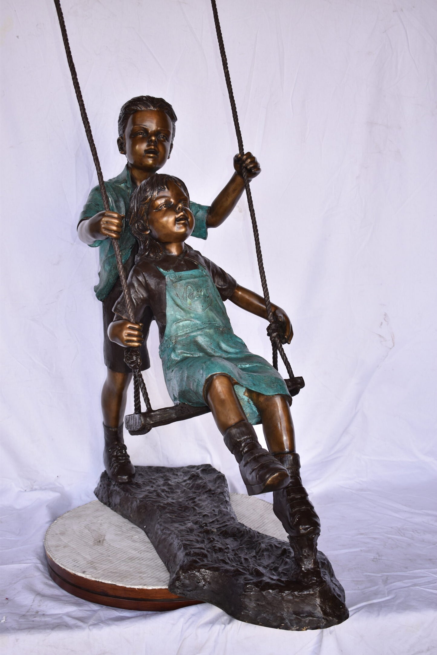 Boy and Girl Playing on a Swing bronze Statue - Size: 39"L x 17"W x 53"H.