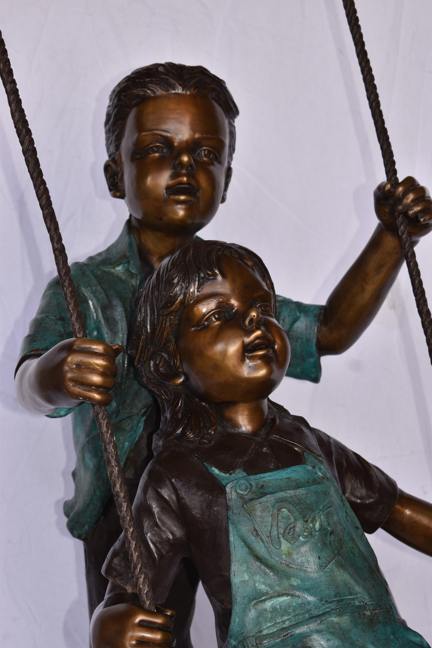 Boy and Girl Playing on a Swing bronze Statue - Size: 39"L x 17"W x 53"H.