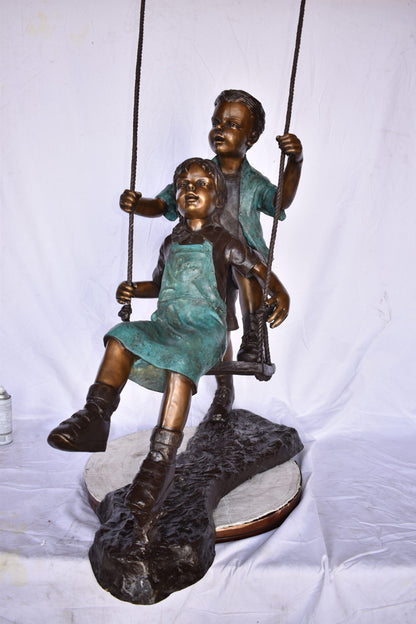 Boy and Girl Playing on a Swing bronze Statue - Size: 39"L x 17"W x 53"H.
