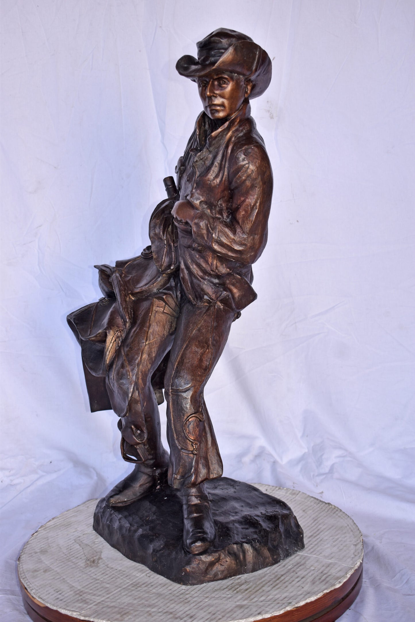 Cowboy Holding His Saddle Bronze Statue - Size: 20"L x 14"W x 35"H.