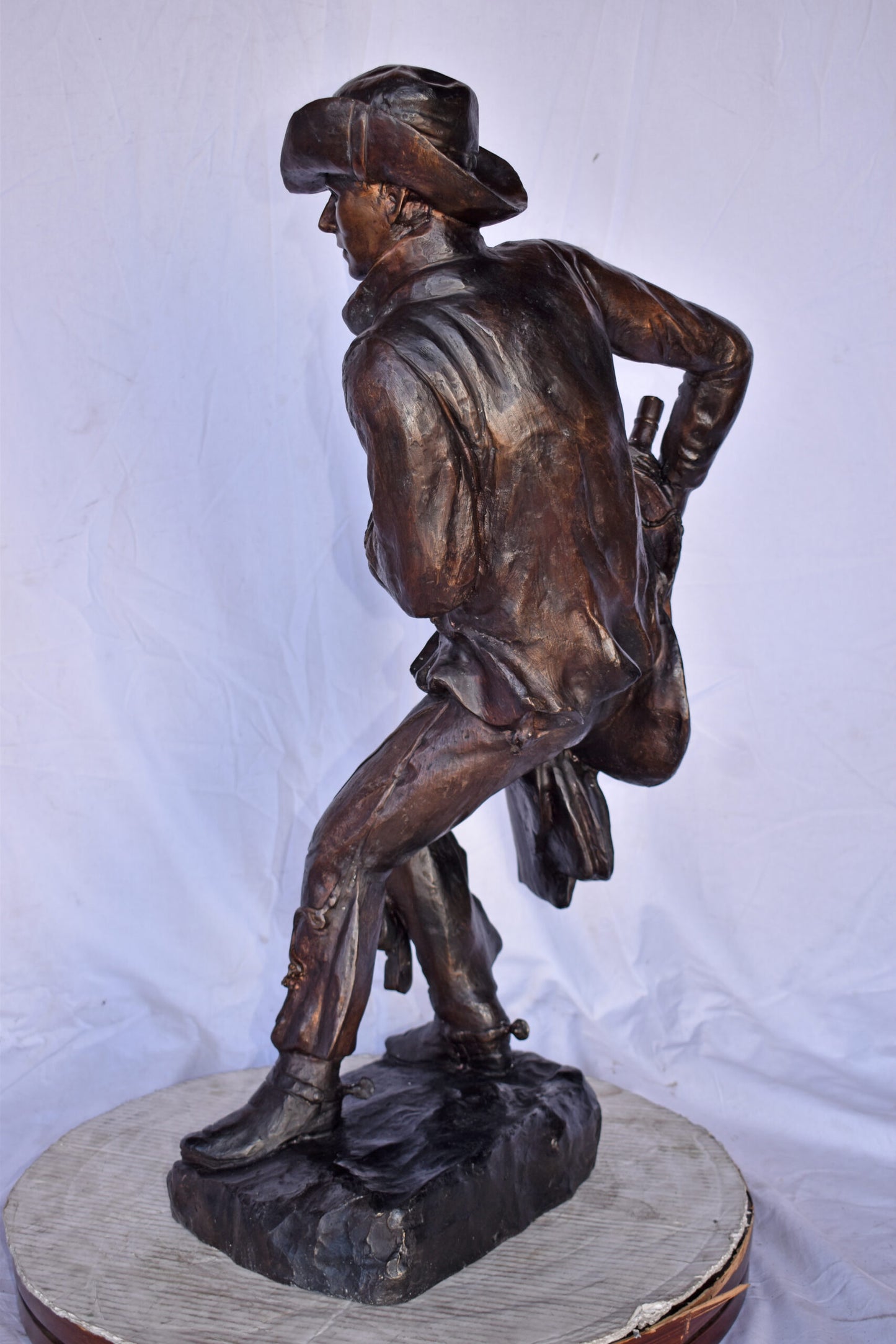 Cowboy Holding His Saddle Bronze Statue - Size: 20"L x 14"W x 35"H.