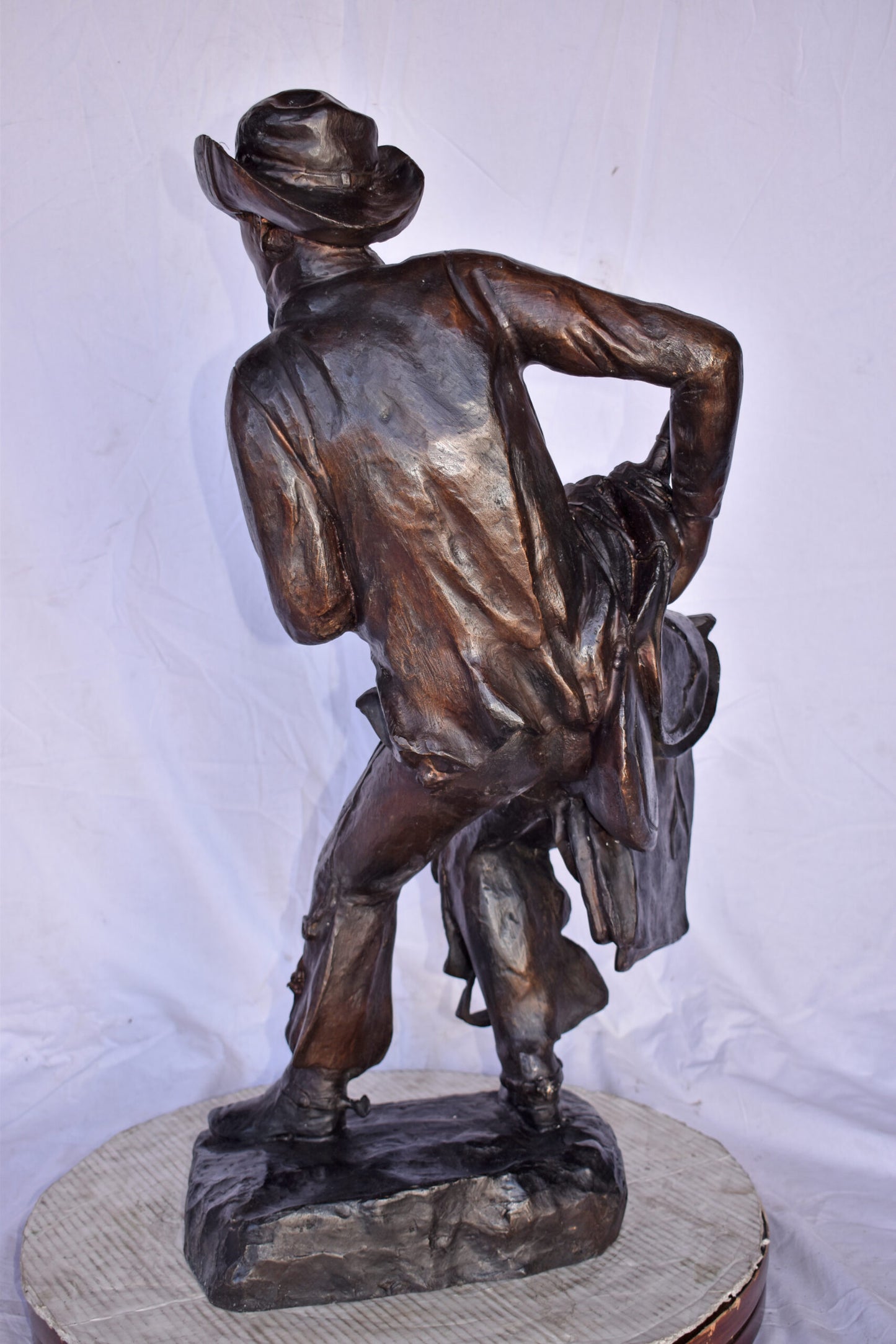 Cowboy Holding His Saddle Bronze Statue - Size: 20"L x 14"W x 35"H.