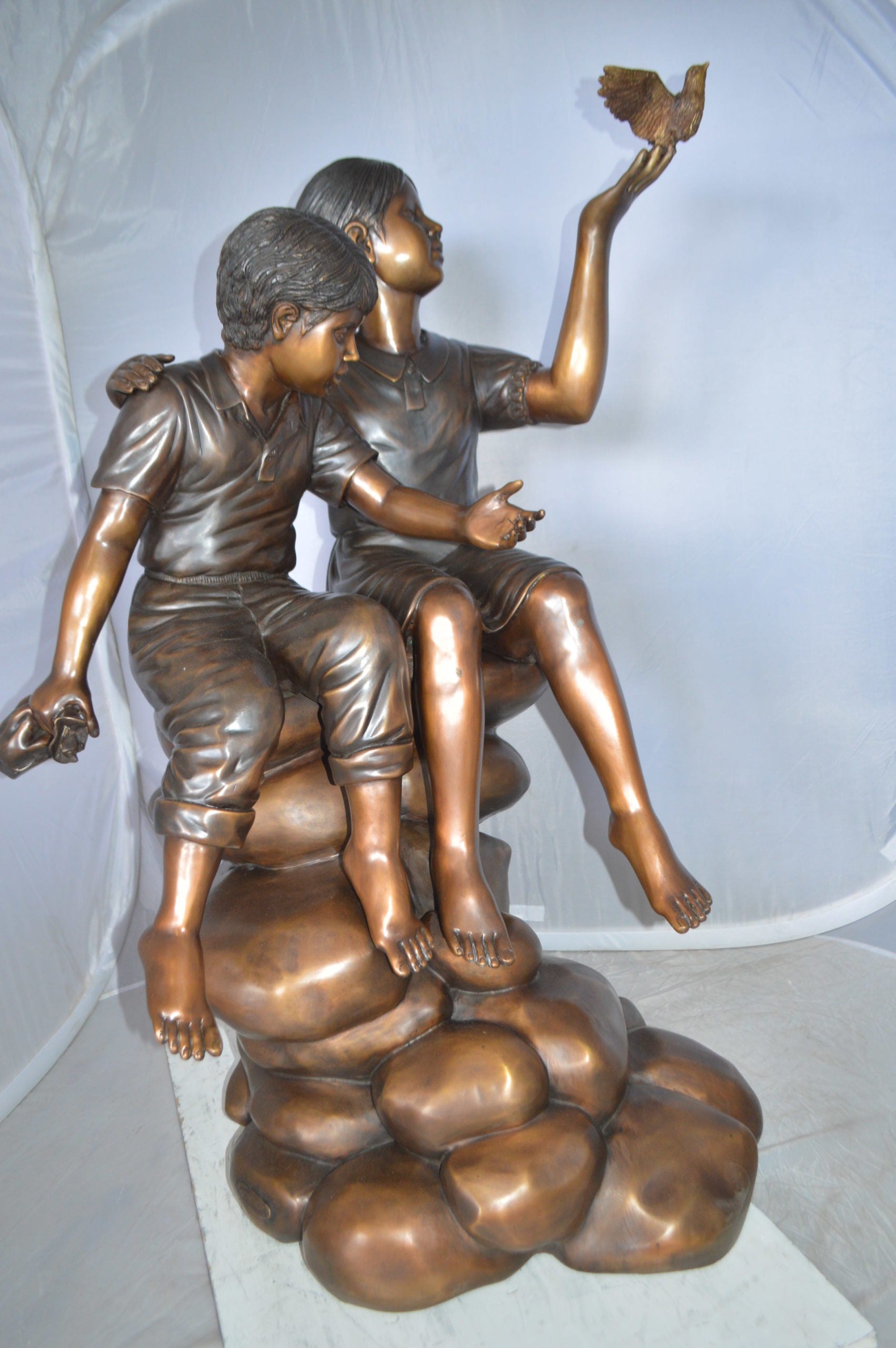 Two Kids on Rocks with a Bird Bronze Statue -  Size: 36"L x 30"W x 44"H. 