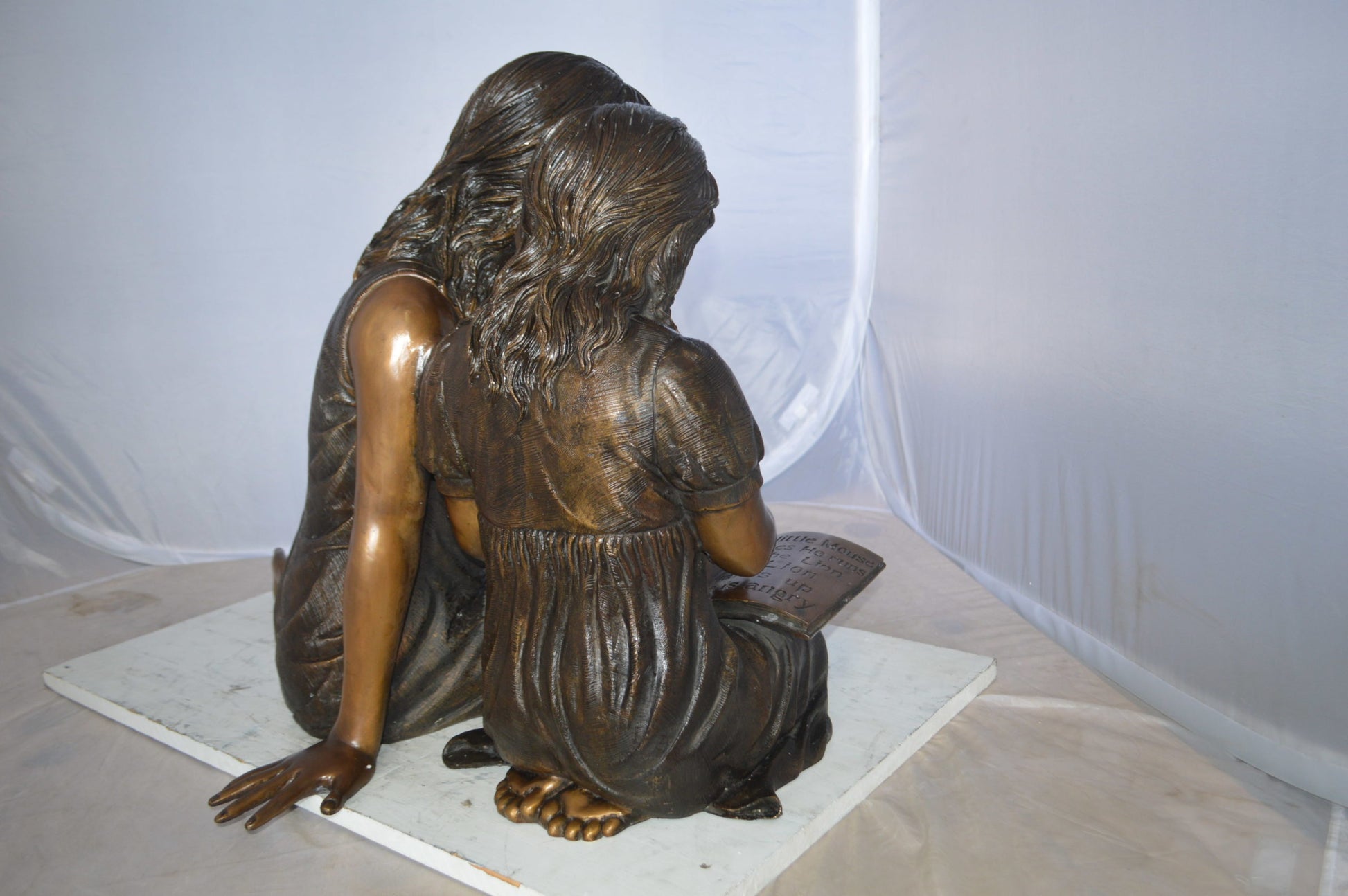Two Girls Reading a Book Bronze Statue -  Size: 33"L x 21"W x 23"H. 