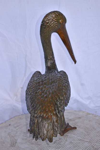 Pelican Standing and Looking Down Bronze Statue - Size: 20"L x 8"W x 22"H.
