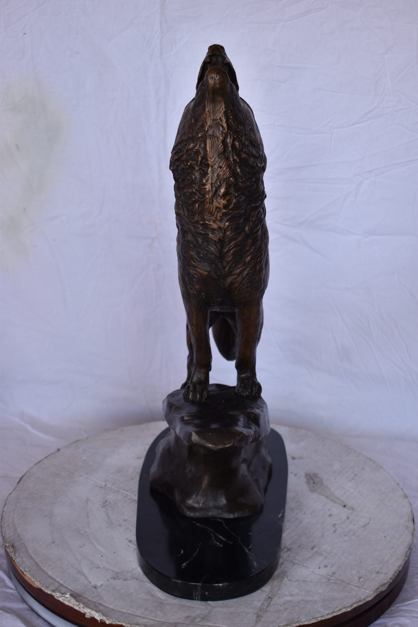 Howling Wolf at Edge of a Cliff Bronze Statue - Size: 9"L x 20"W x 26"H.